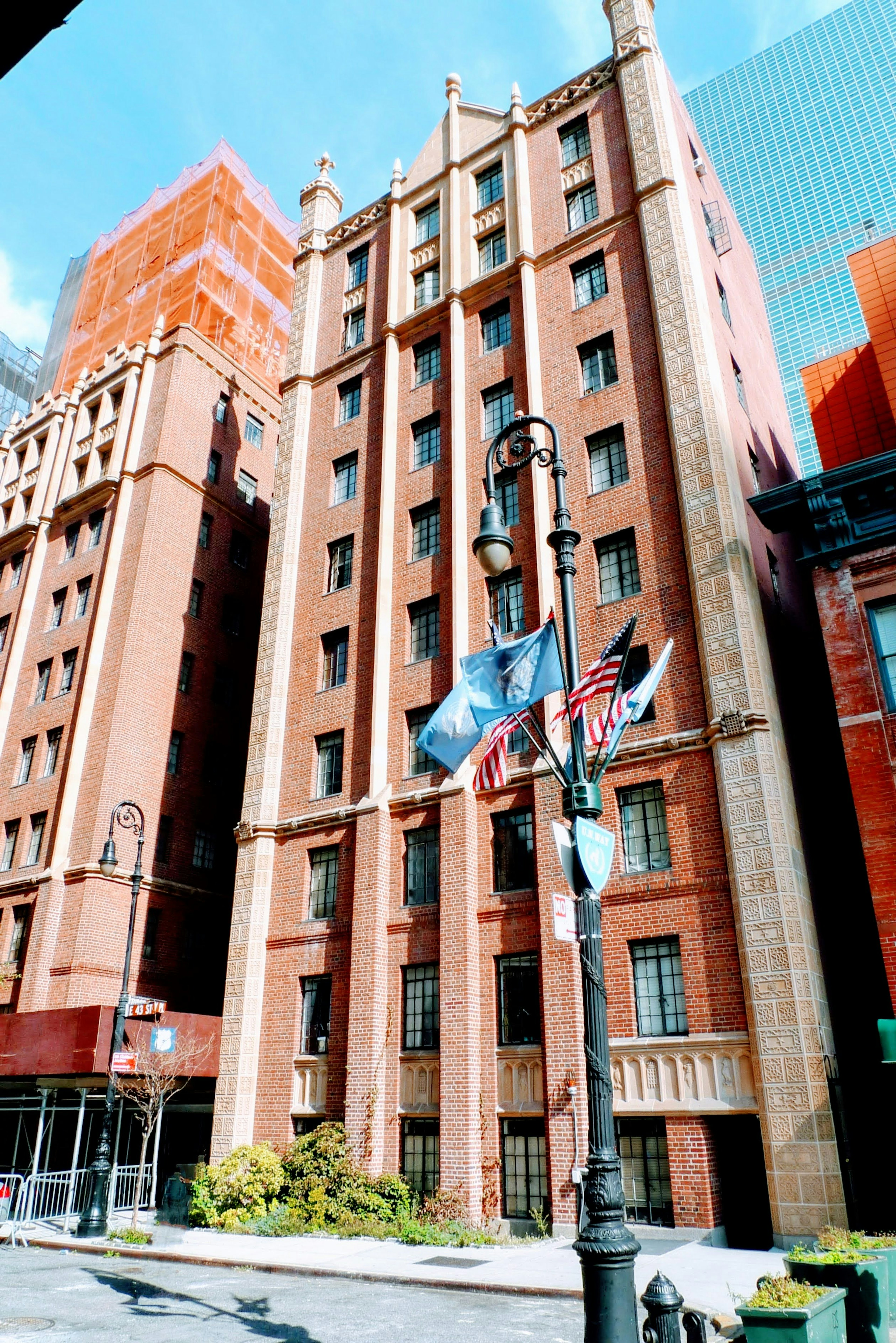 Edificio histórico con fachada de ladrillo rojo y banderas delante