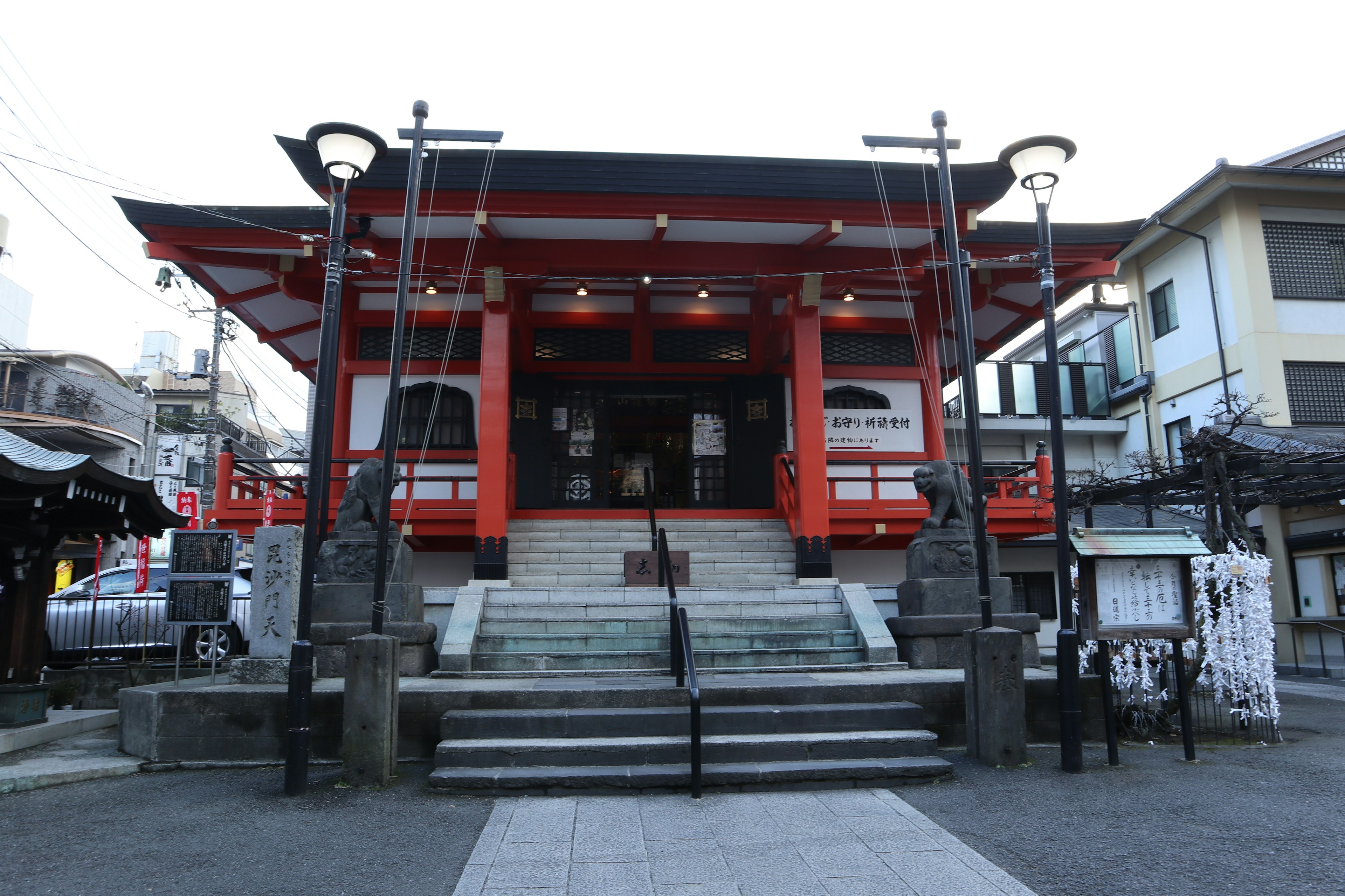 傳統日本神社的外觀，紅色屋頂，帶有階梯和石像