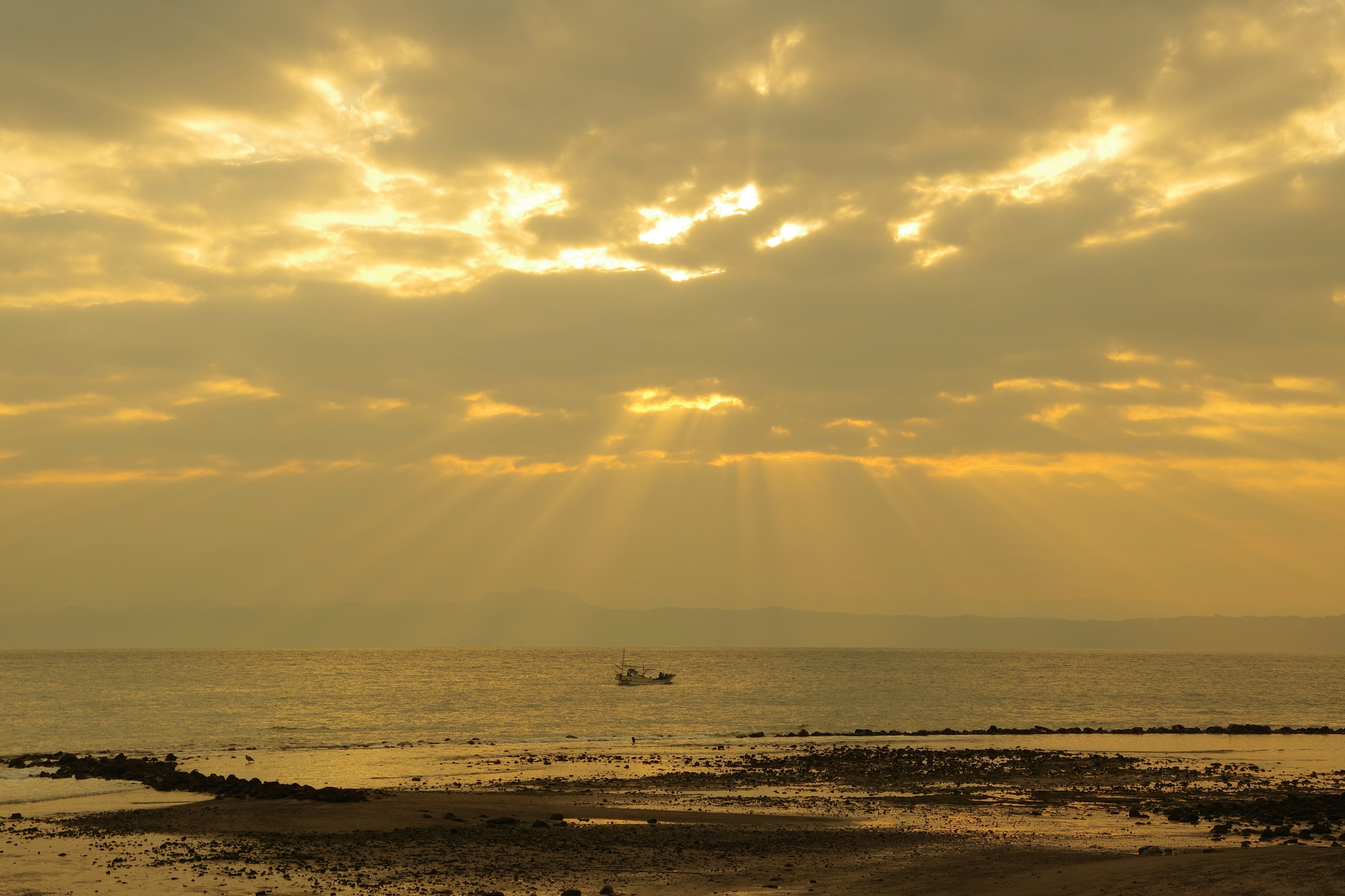 Paysage magnifique avec la lumière du soleil perçant à travers les nuages au-dessus de la mer calme