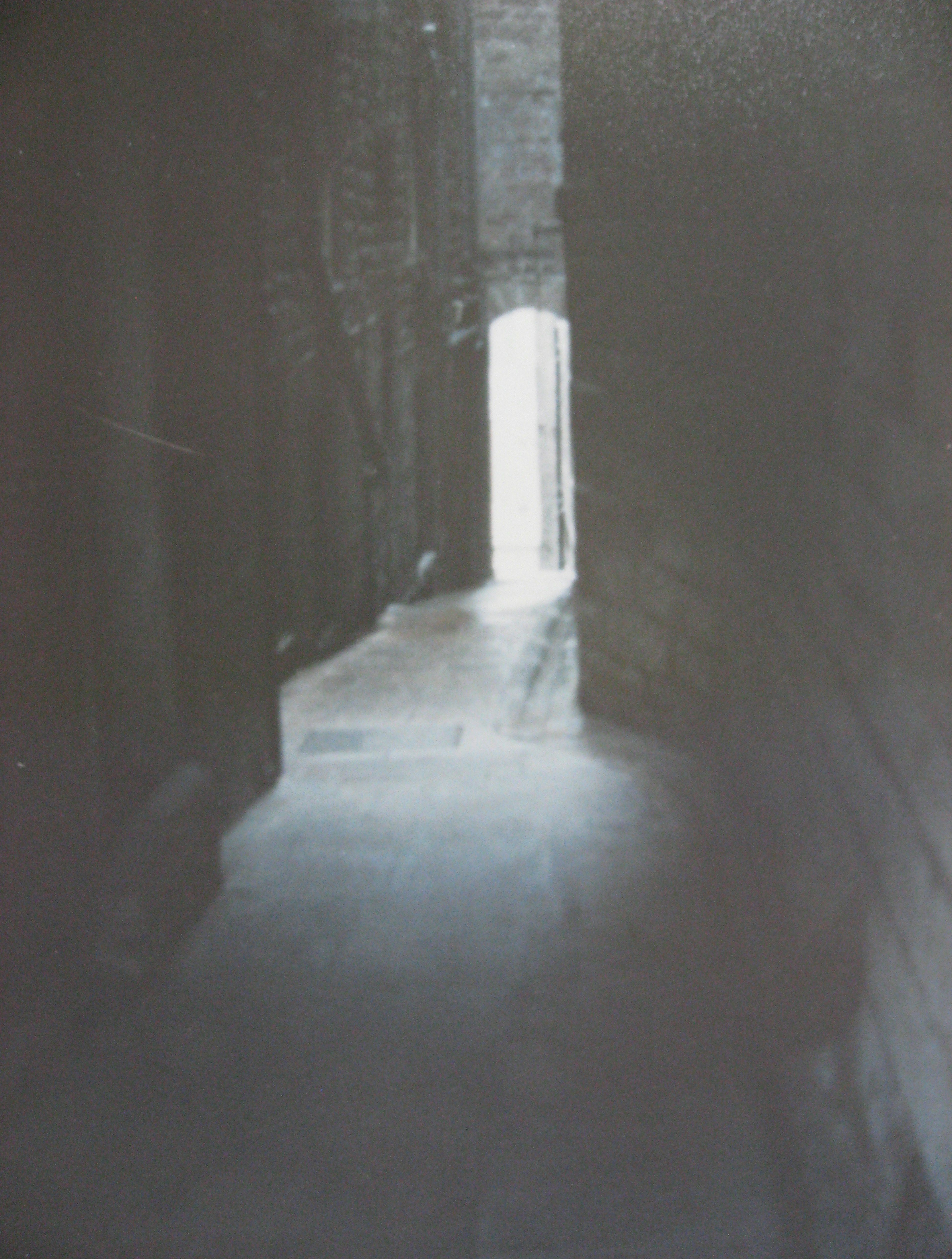 Narrow alleyway leading to bright light