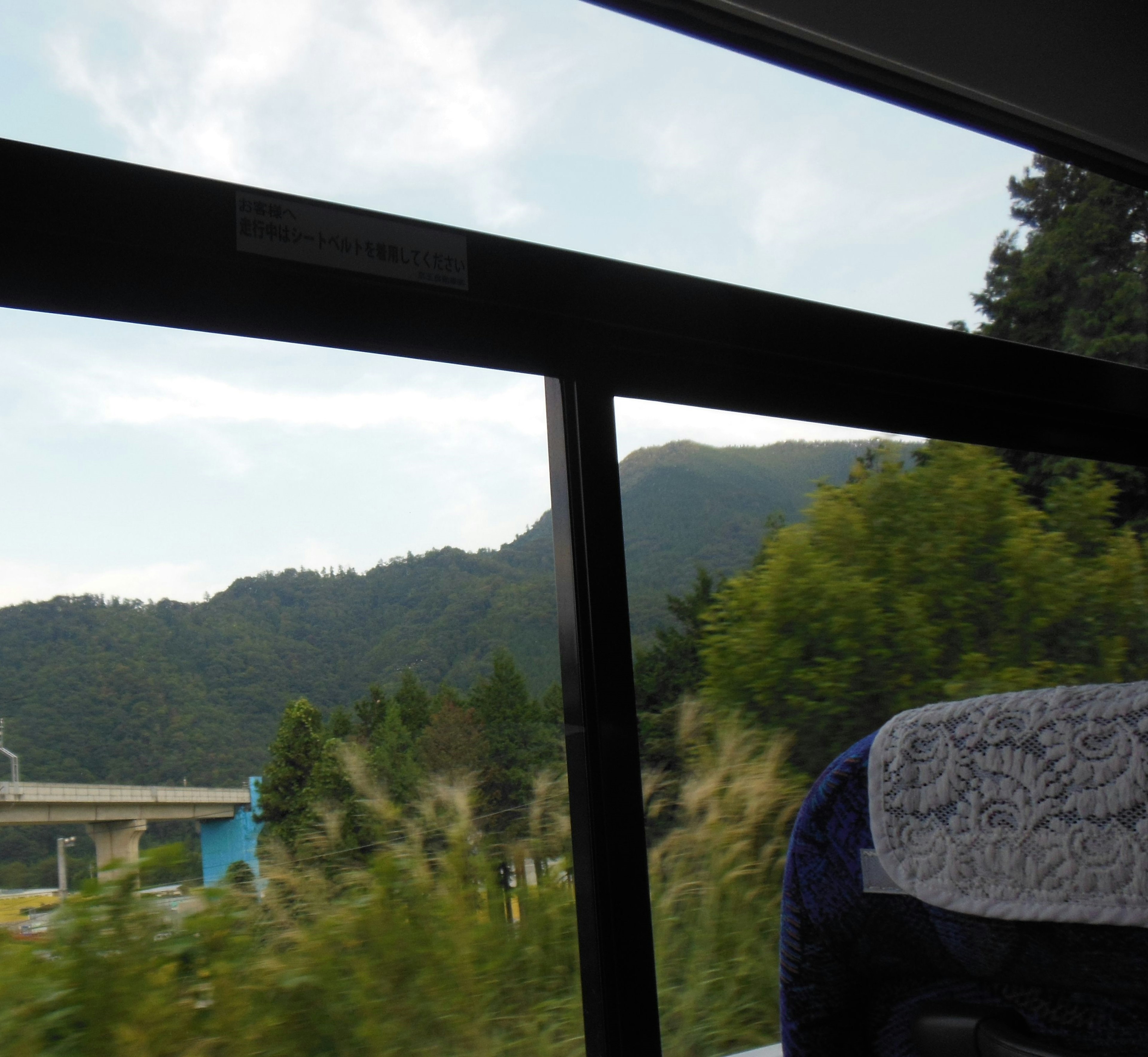 Vue pittoresque des montagnes et de la verdure à travers une fenêtre de bus