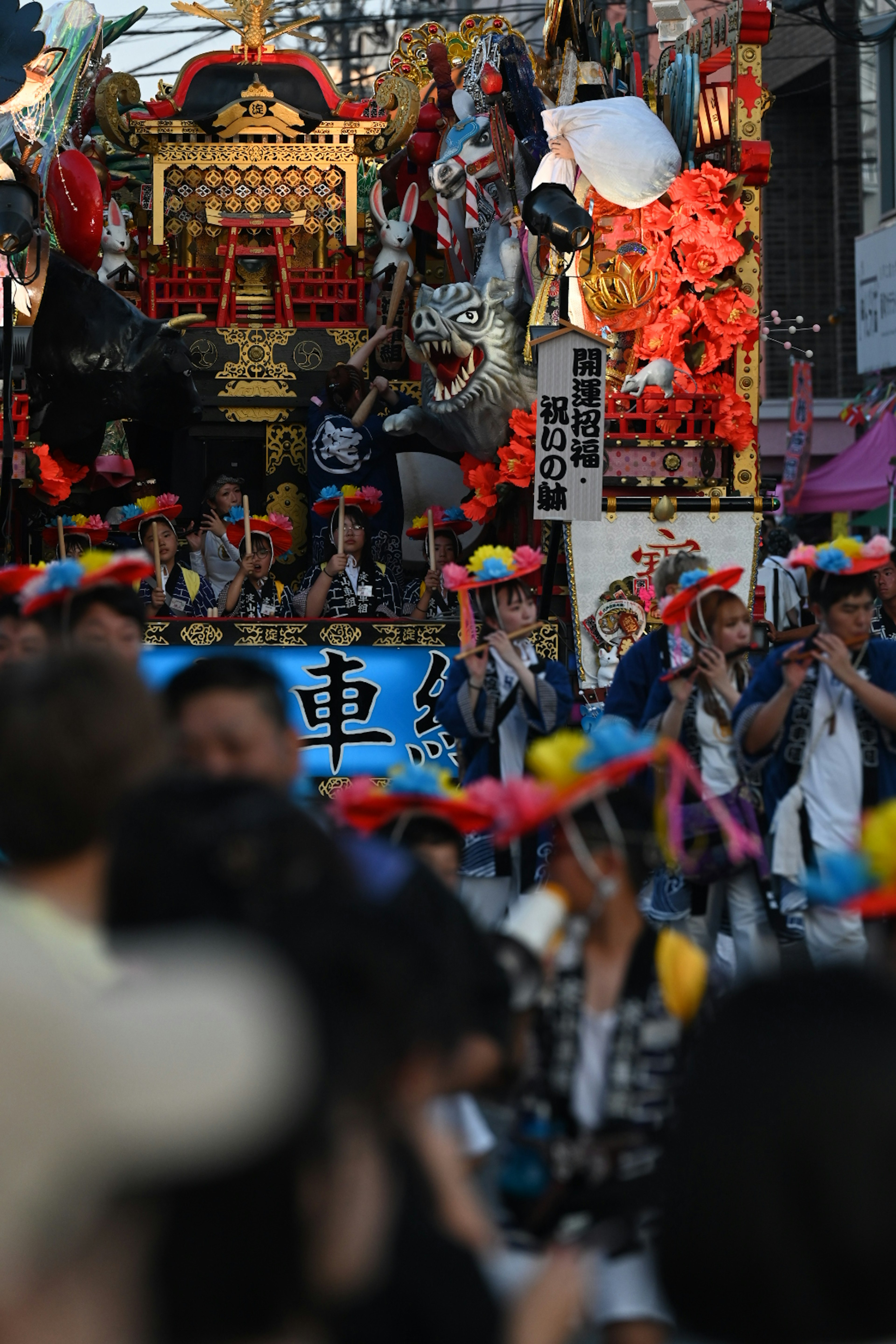 祭りの行列に彩られた山車と参加者の群れ