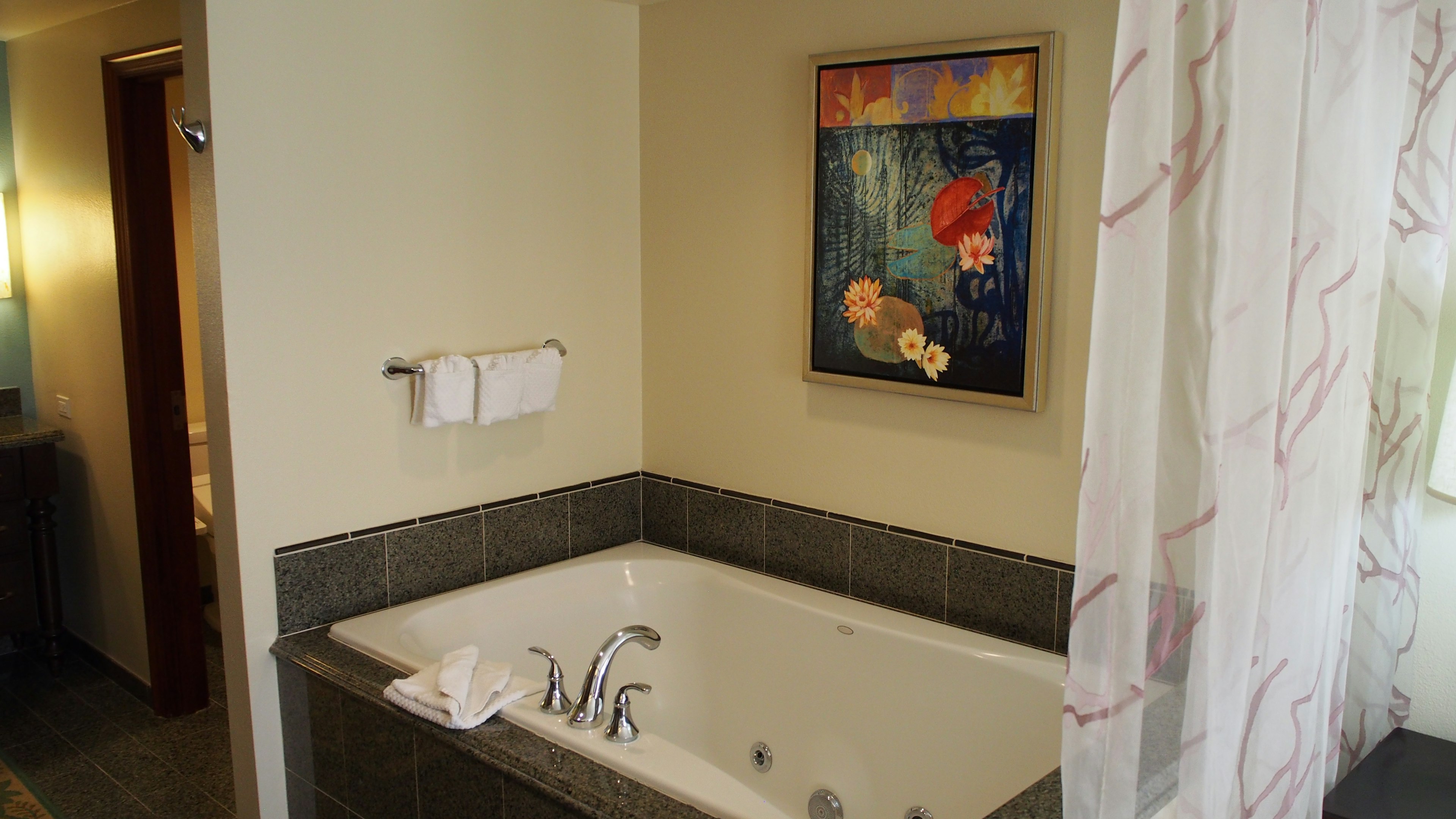 Simple bathroom interior featuring a jacuzzi and artwork