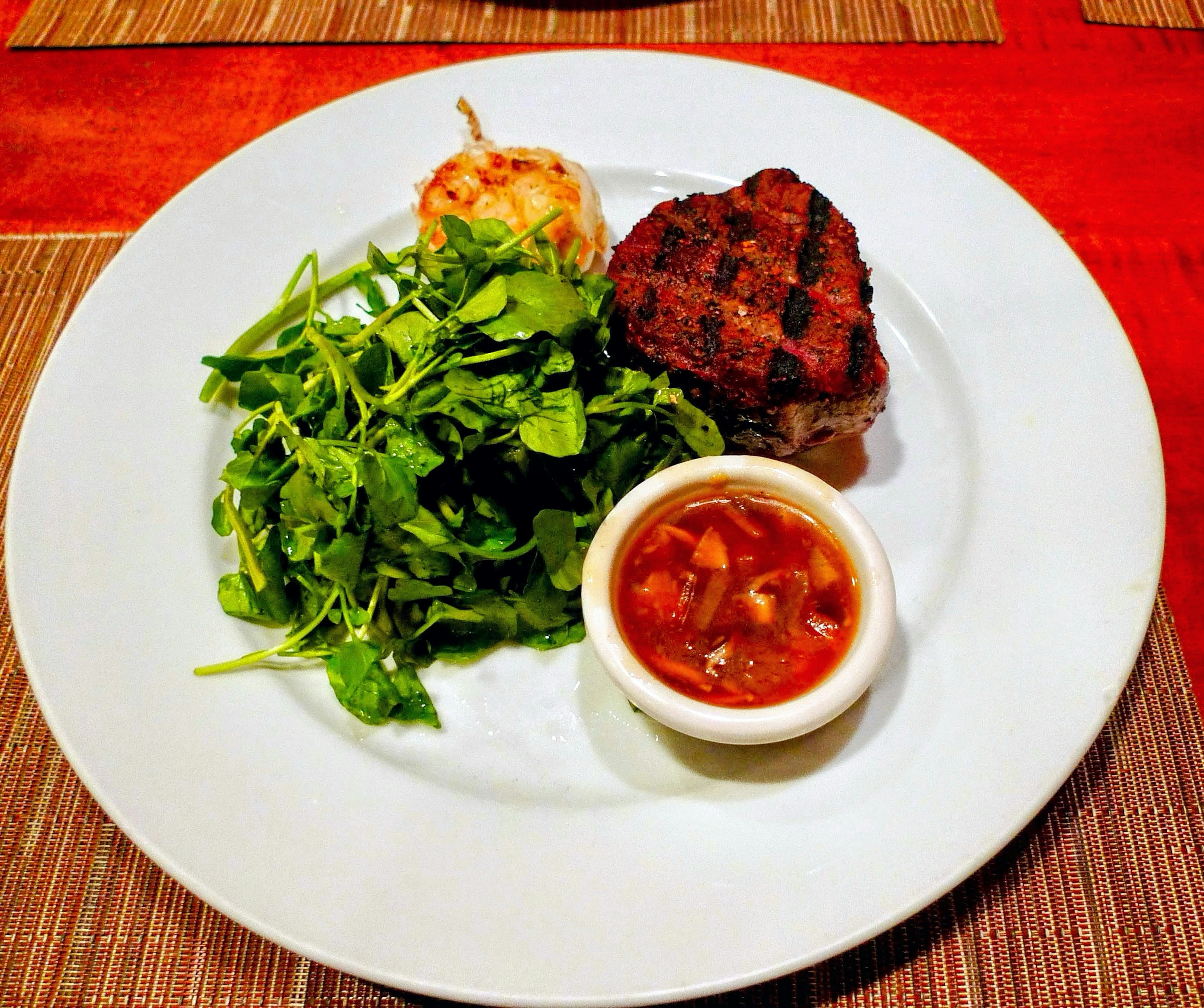 Steak grillé servi avec une salade et une sauce à tremper