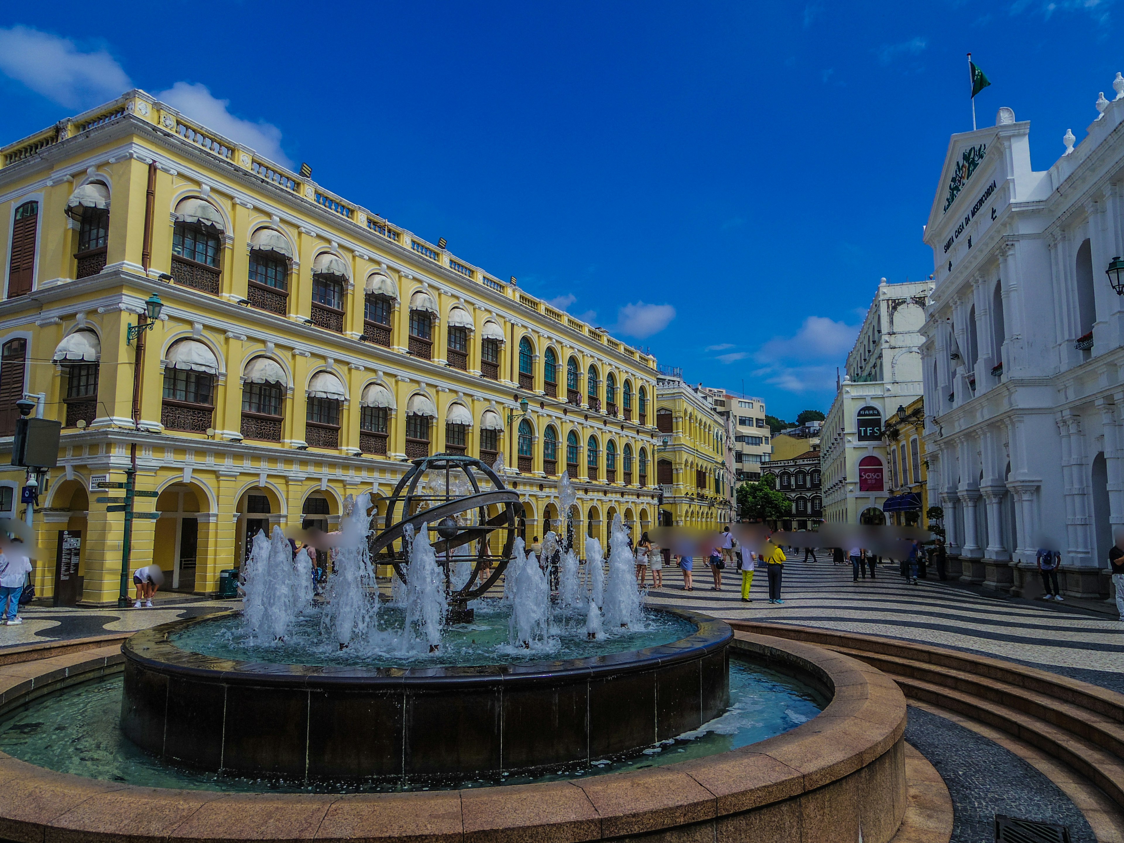 Fountain in a vibrant square surrounded by historical buildings in Macau