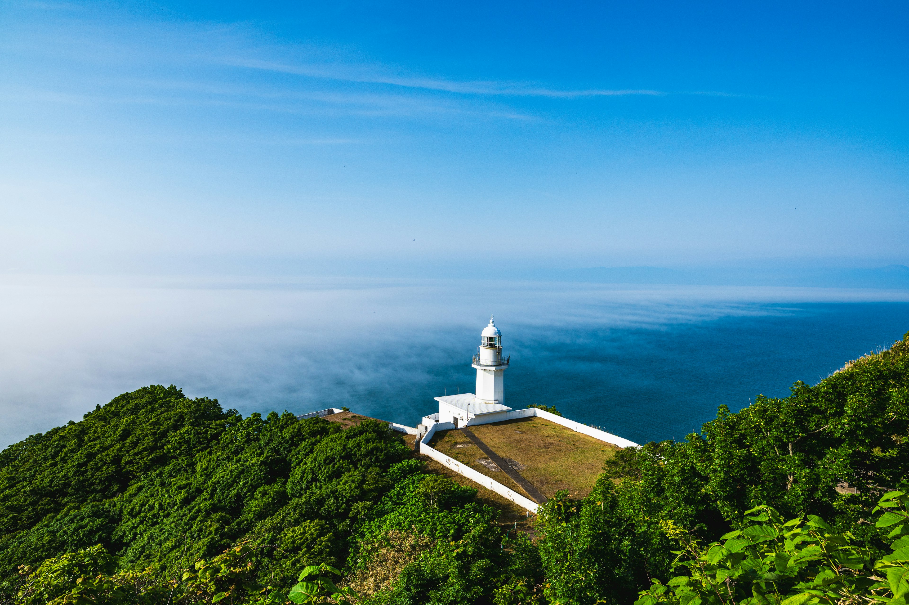 青い空と海に囲まれた灯台の風景