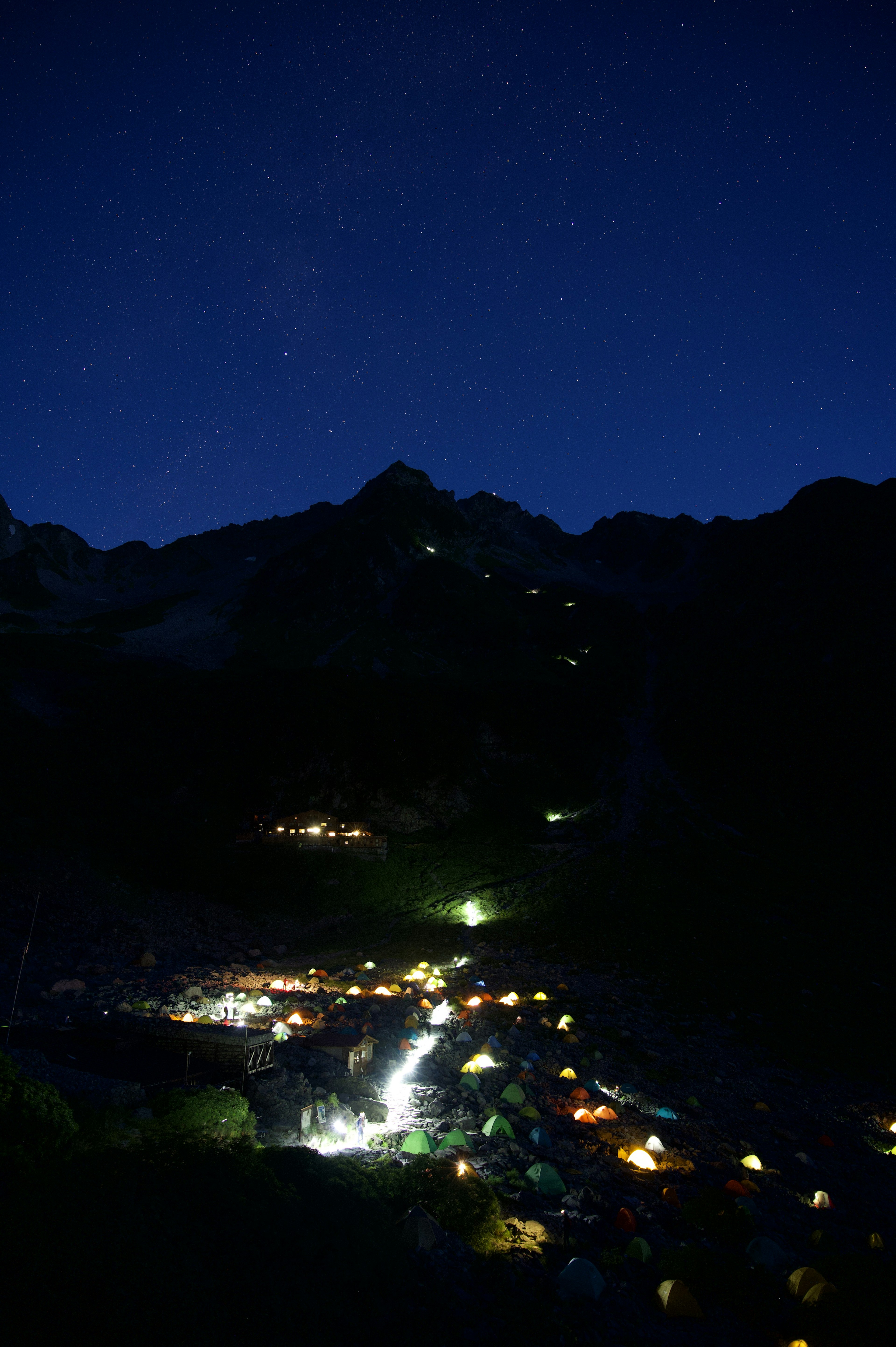 Une scène de village sereine avec des étoiles brillantes dans le ciel nocturne et des montagnes en arrière-plan