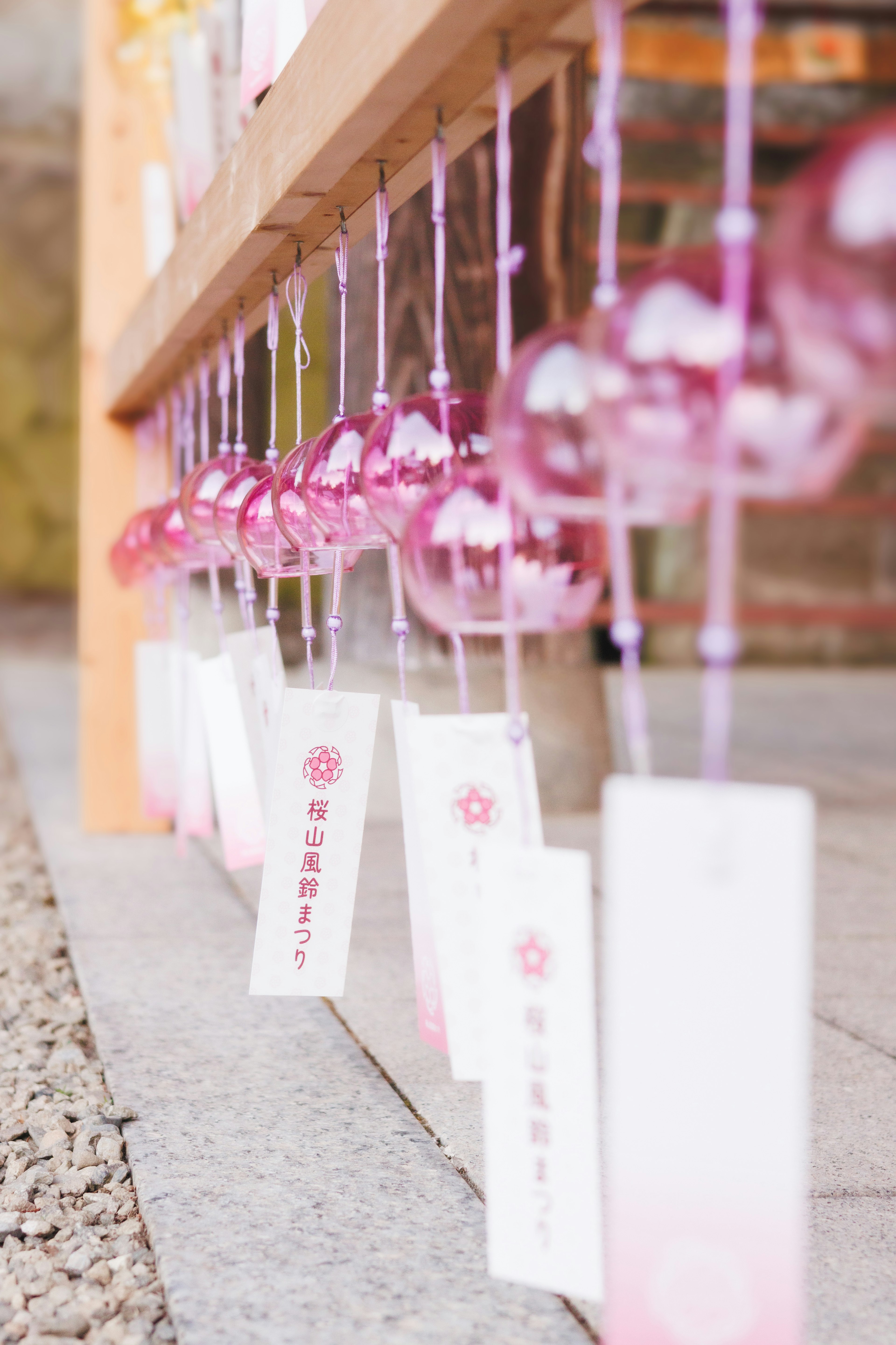 A row of pink wind chimes and white cards