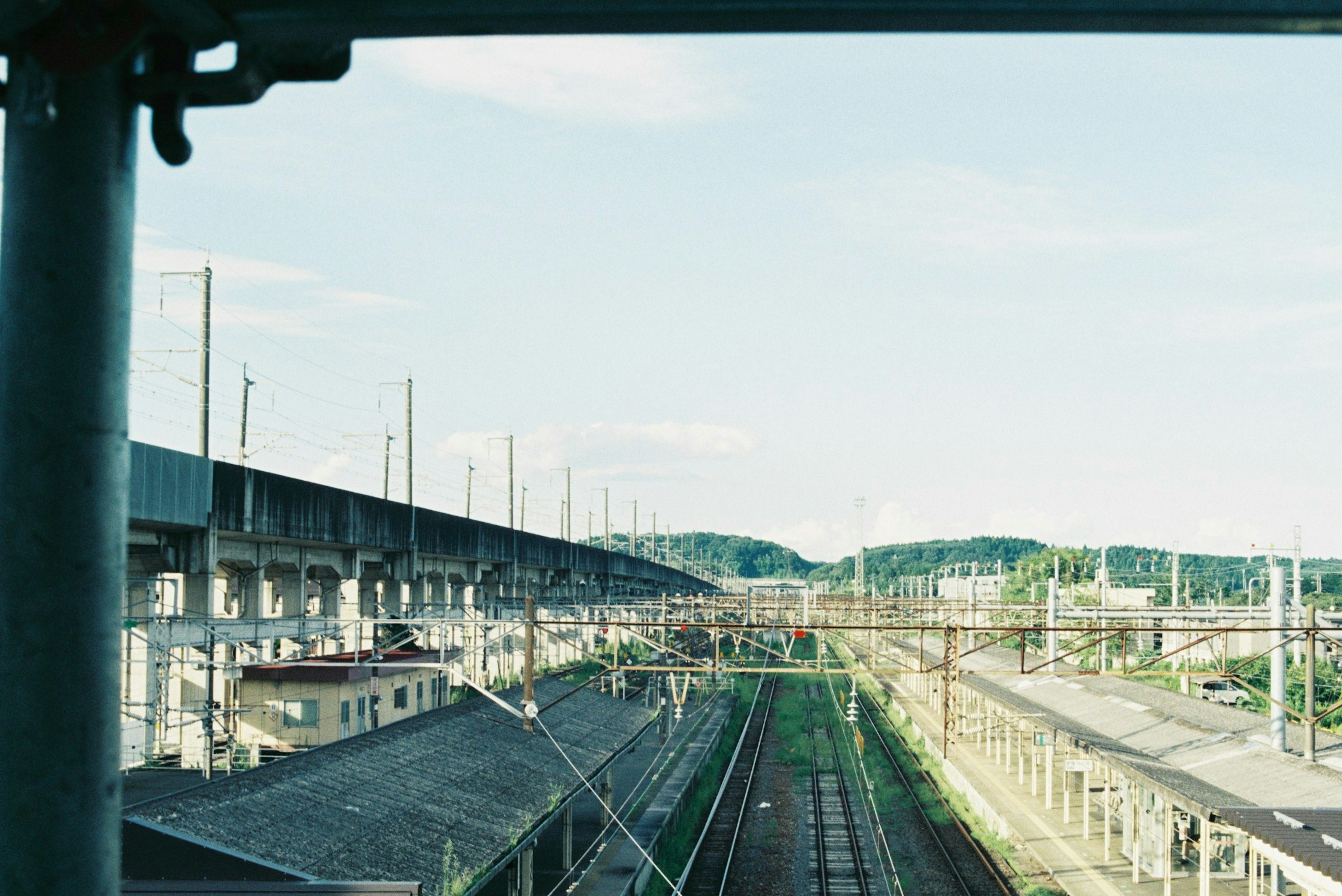 View of railway tracks and elevated structures under a blue sky