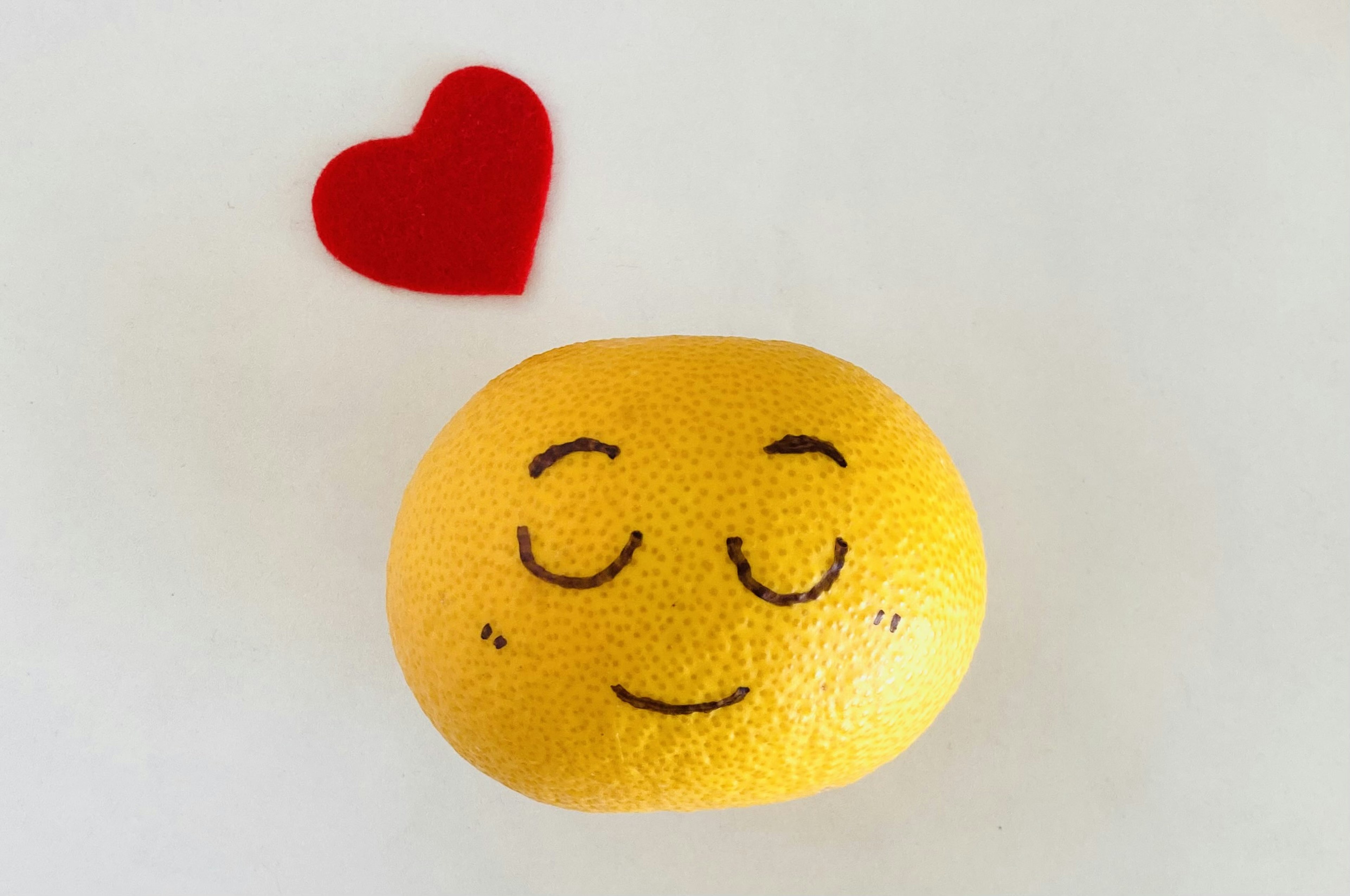 Yellow orange with a smiling face and a red heart decoration