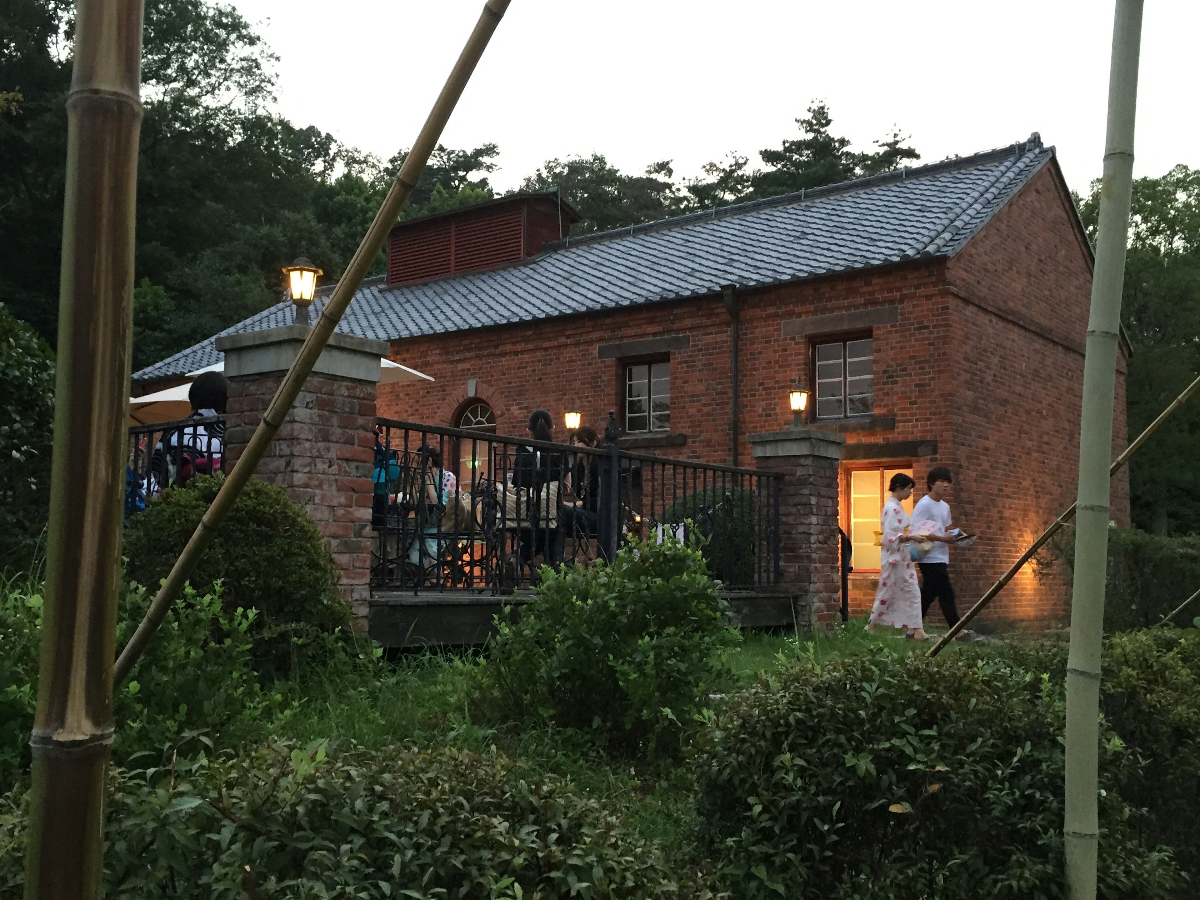 Brick building at dusk surrounded by greenery