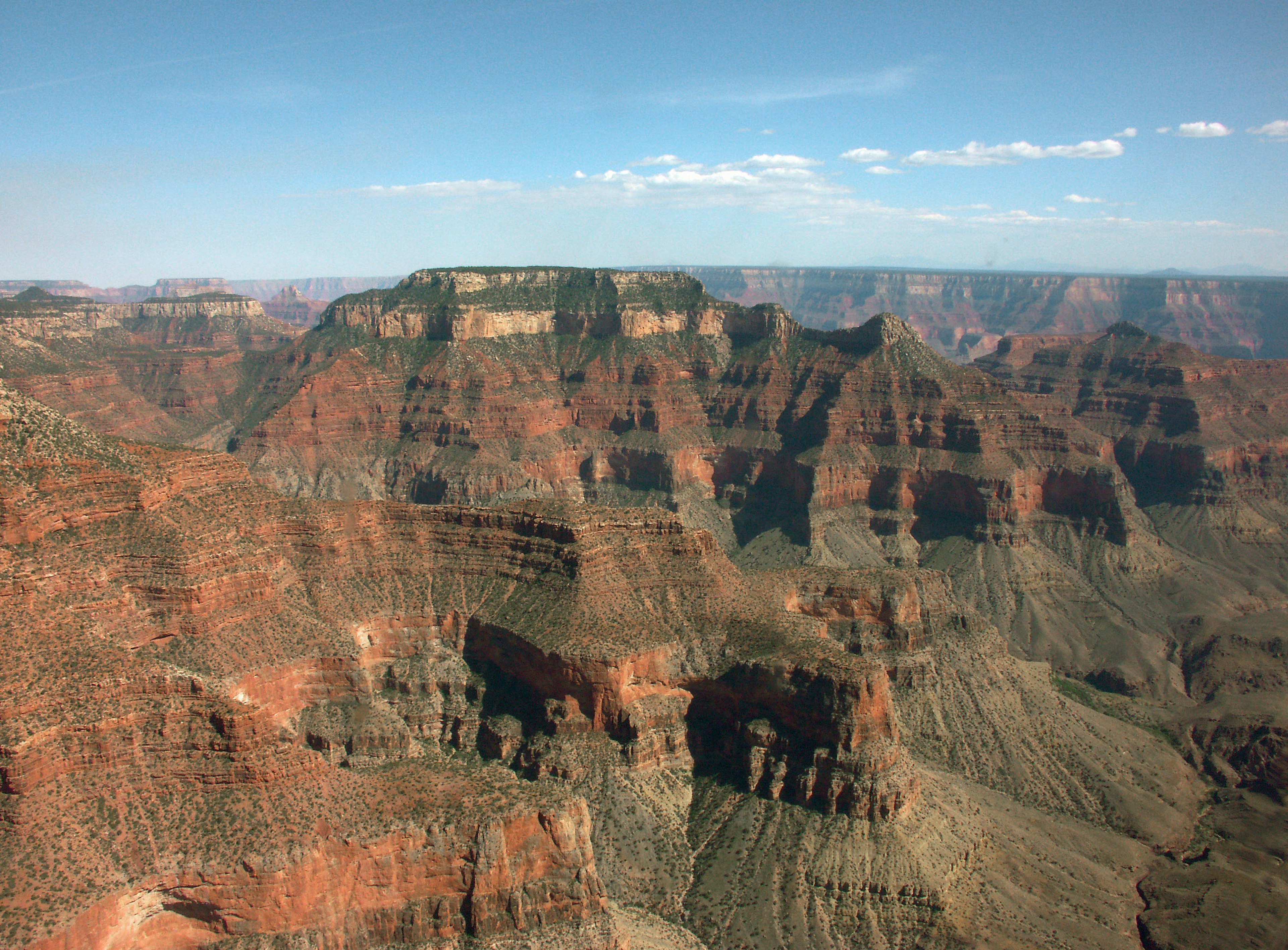 Vue imprenable du Grand Canyon avec des formations rocheuses rouges et un ciel bleu dégagé