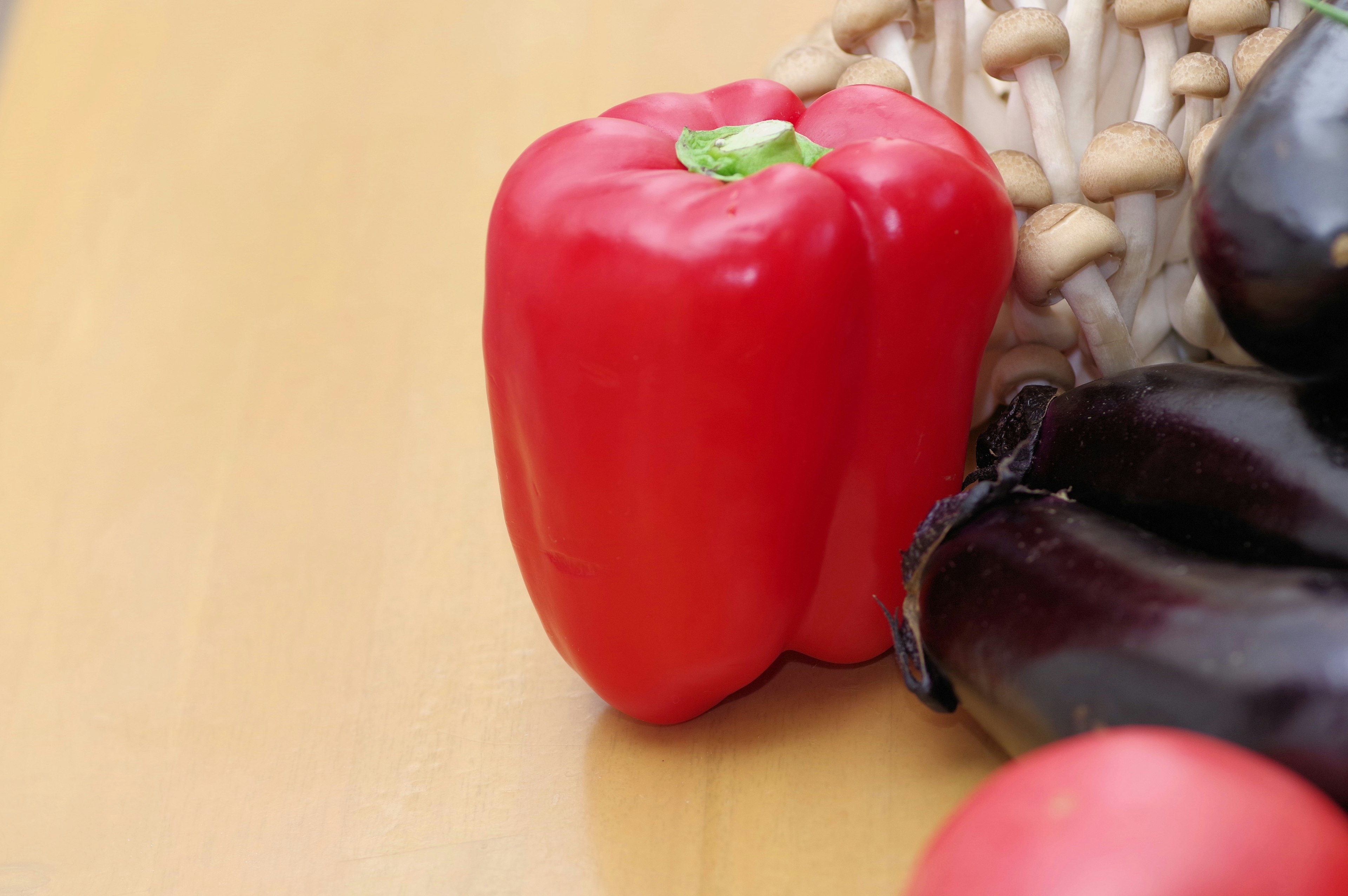 Un poivron rouge posé sur une table en bois