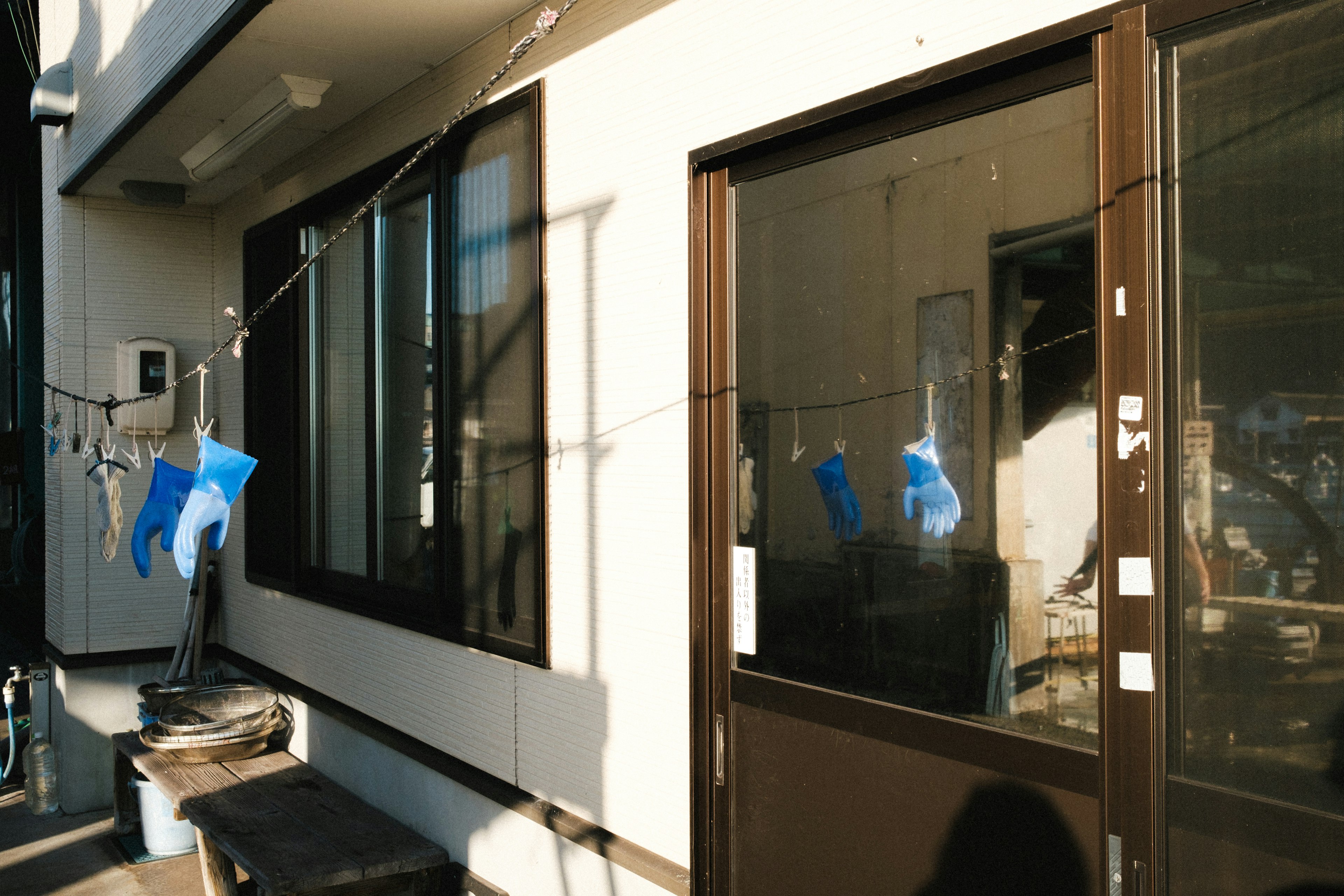 Gants bleus suspendus comme du linge à l'extérieur d'une maison