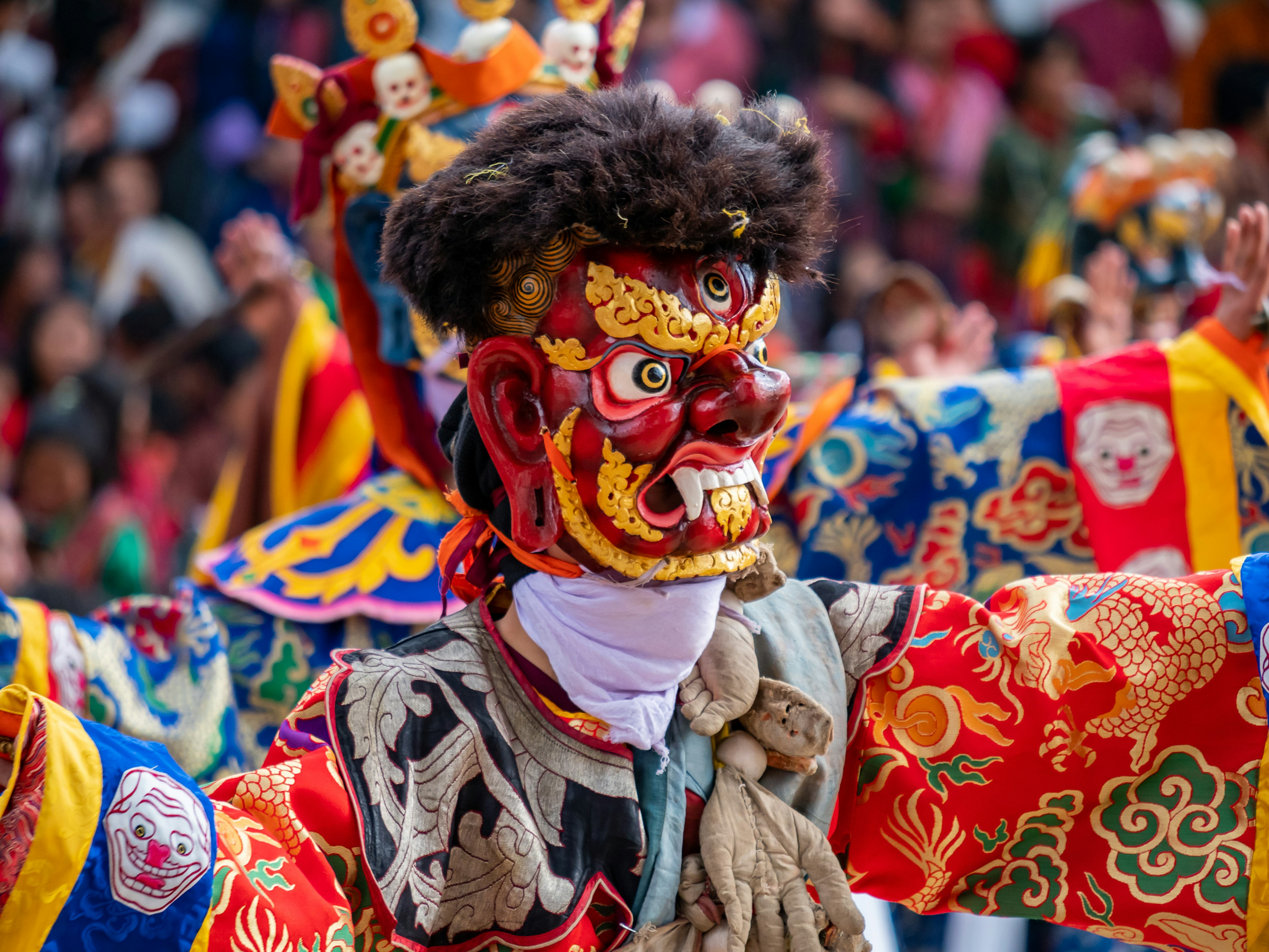 Danzatore tradizionale che indossa un costume vivace e una maschera decorativa mentre si esibisce