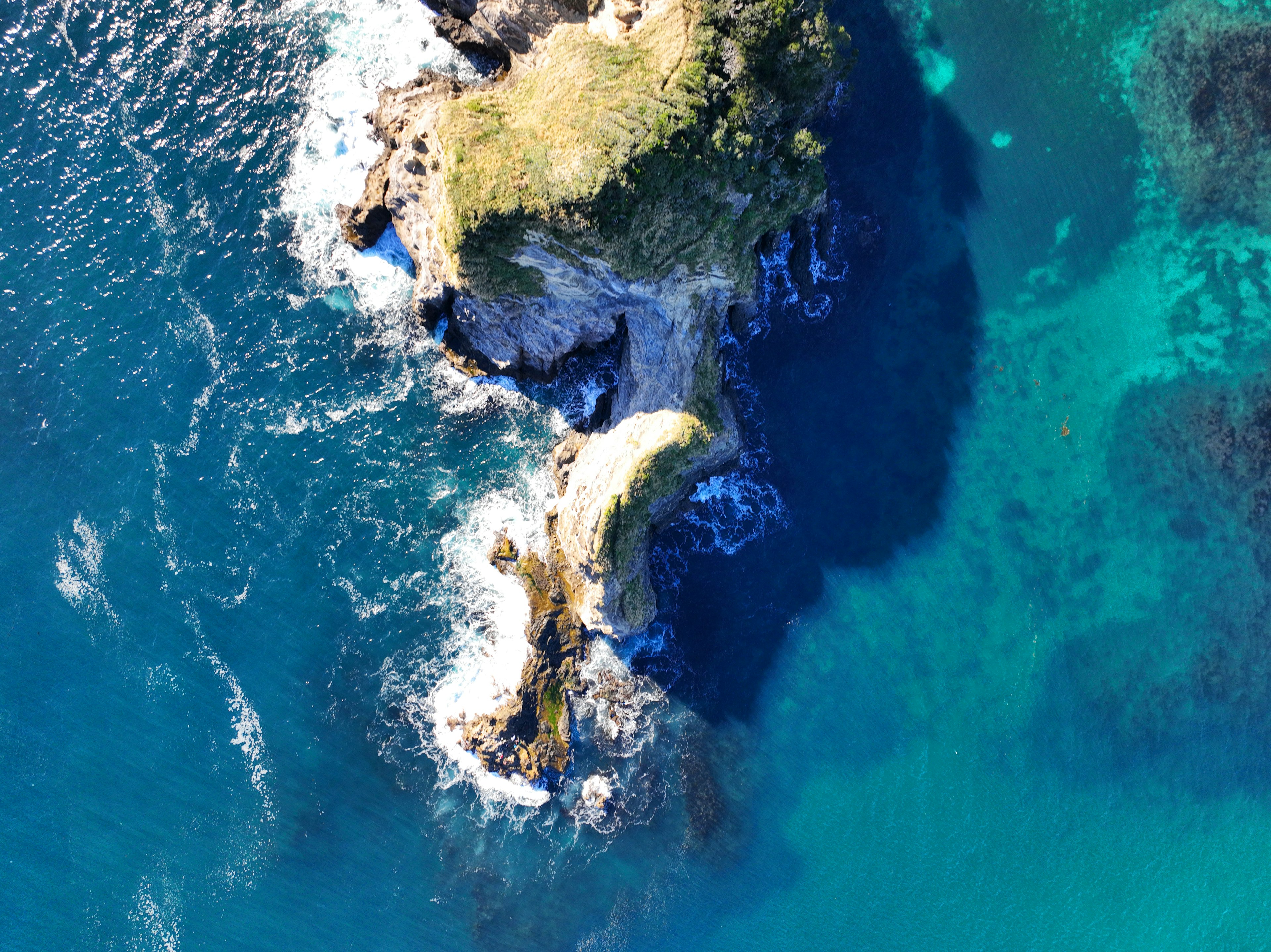 Vue aérienne d'une petite île entourée par l'océan bleu