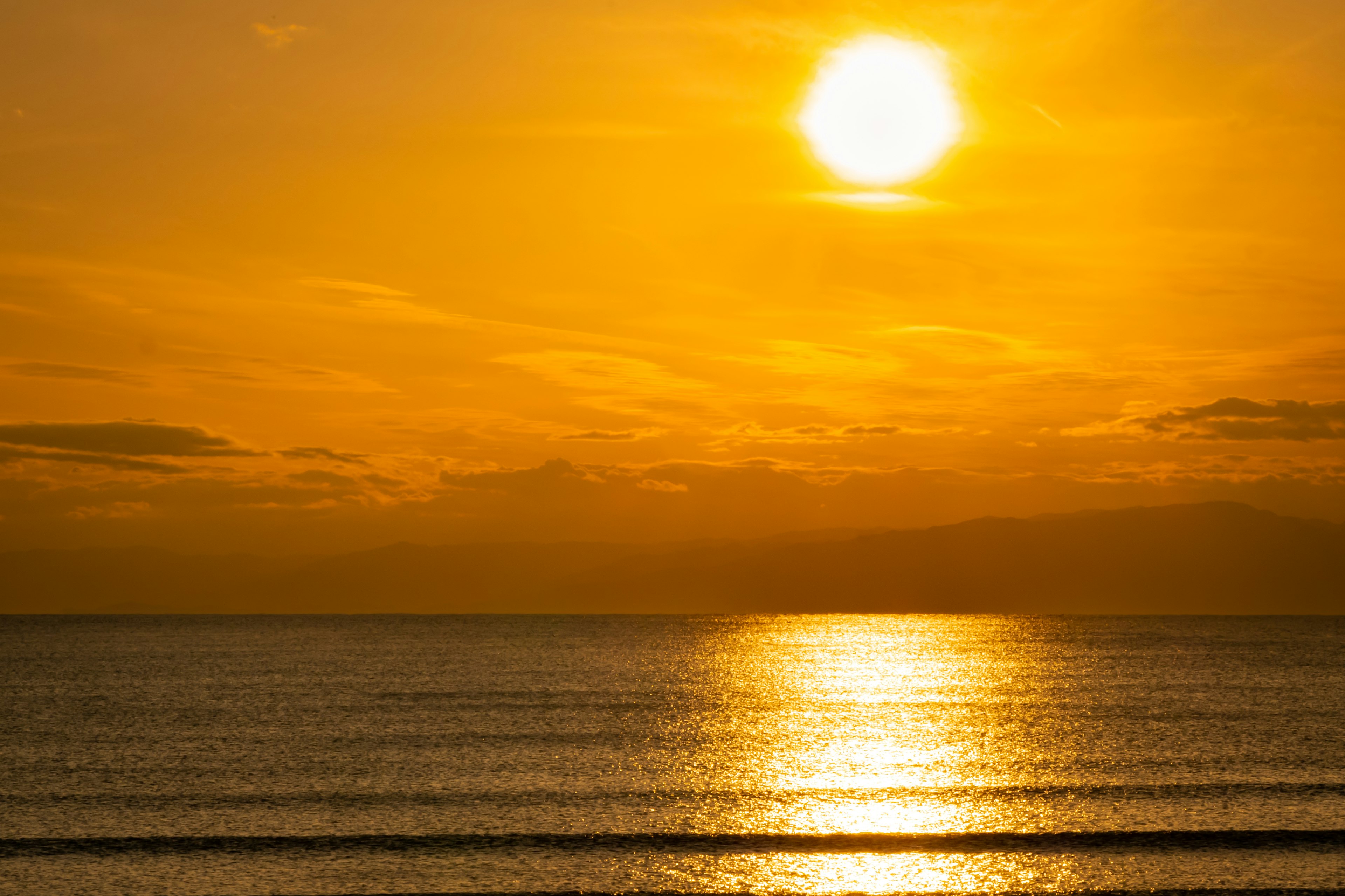 Schöner orangefarbener Sonnenuntergang, der sich im Ozean spiegelt