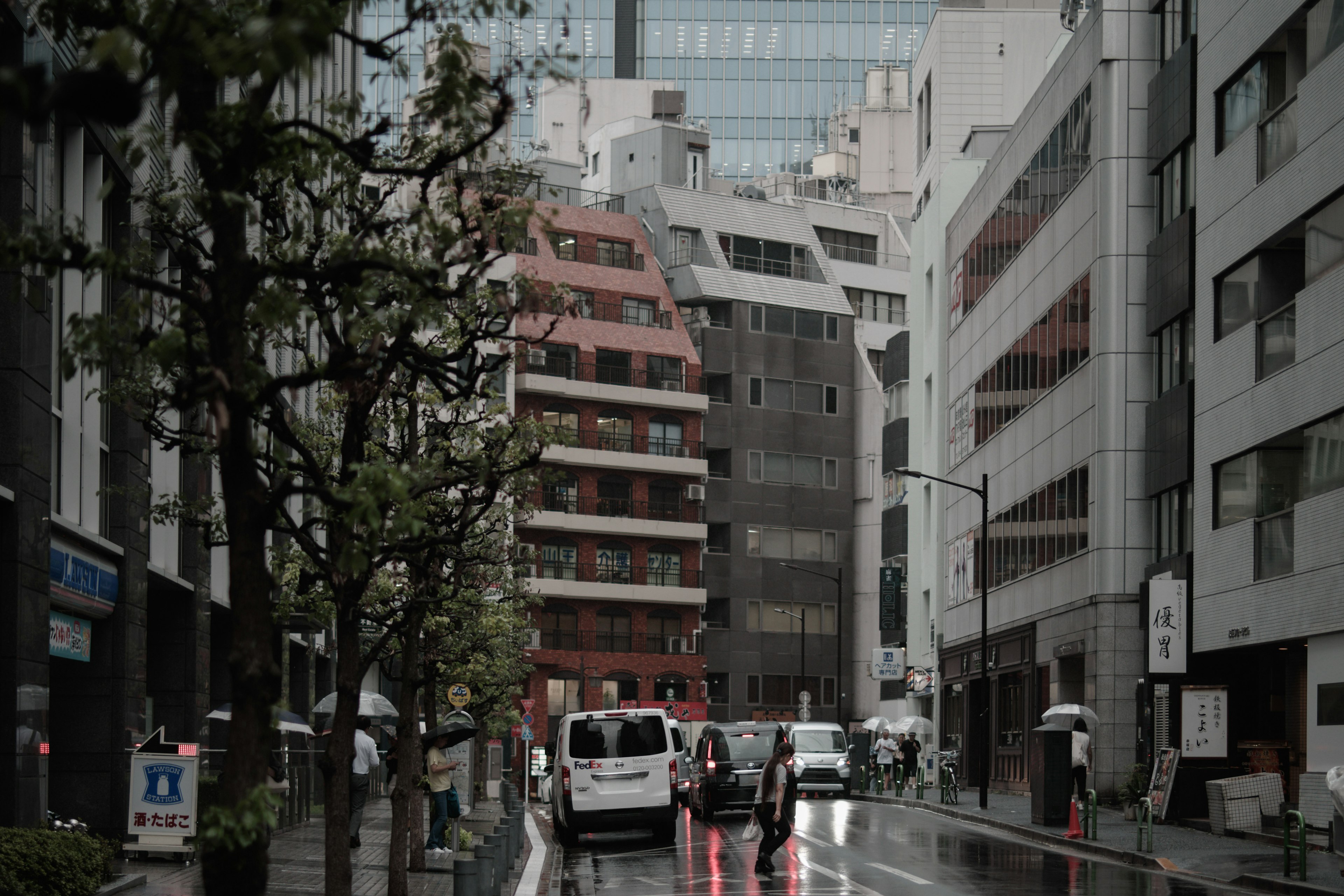 Scène urbaine sous la pluie avec plusieurs bâtiments et véhicules