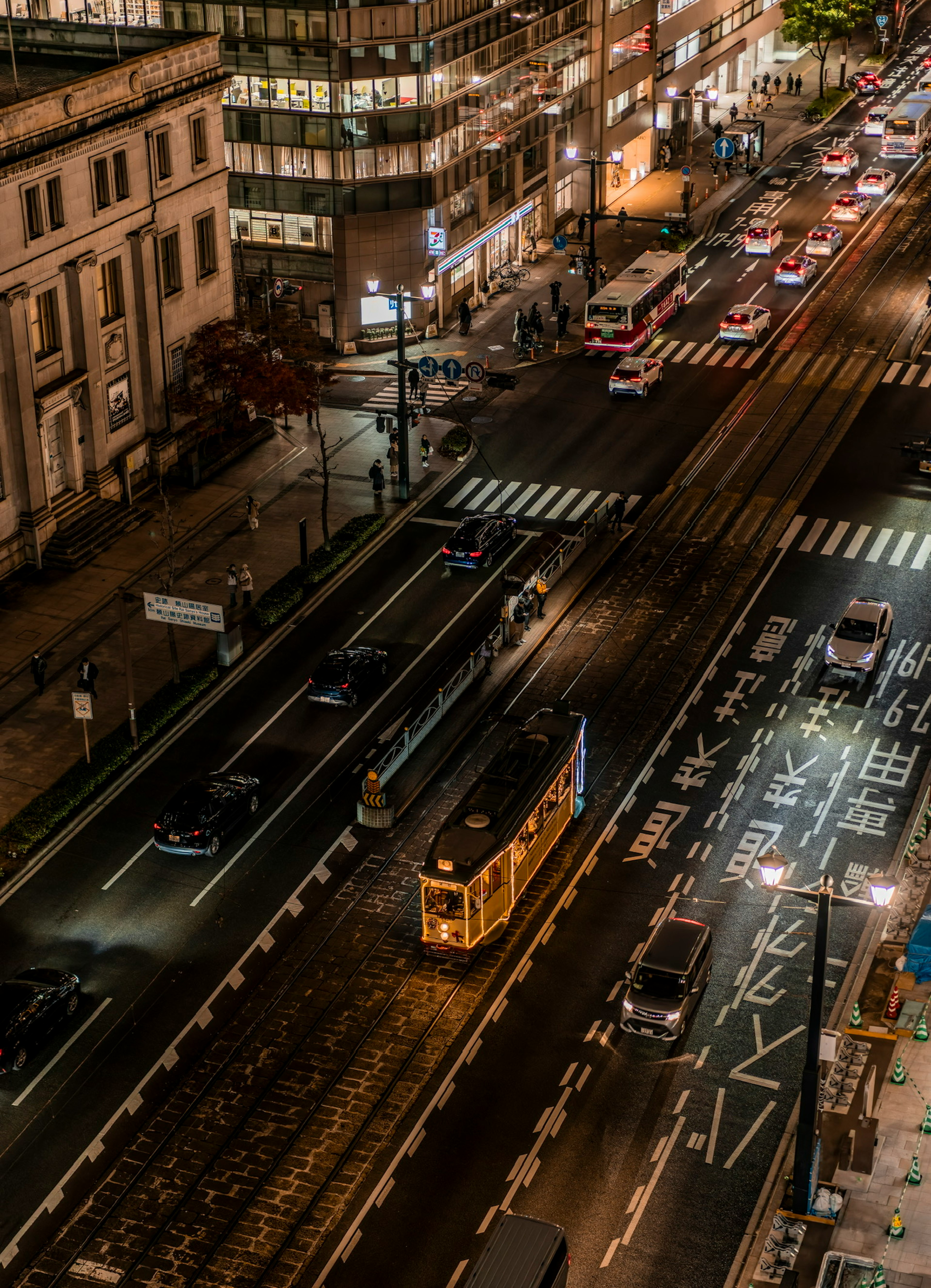 Night cityscape featuring a streetcar and flowing traffic