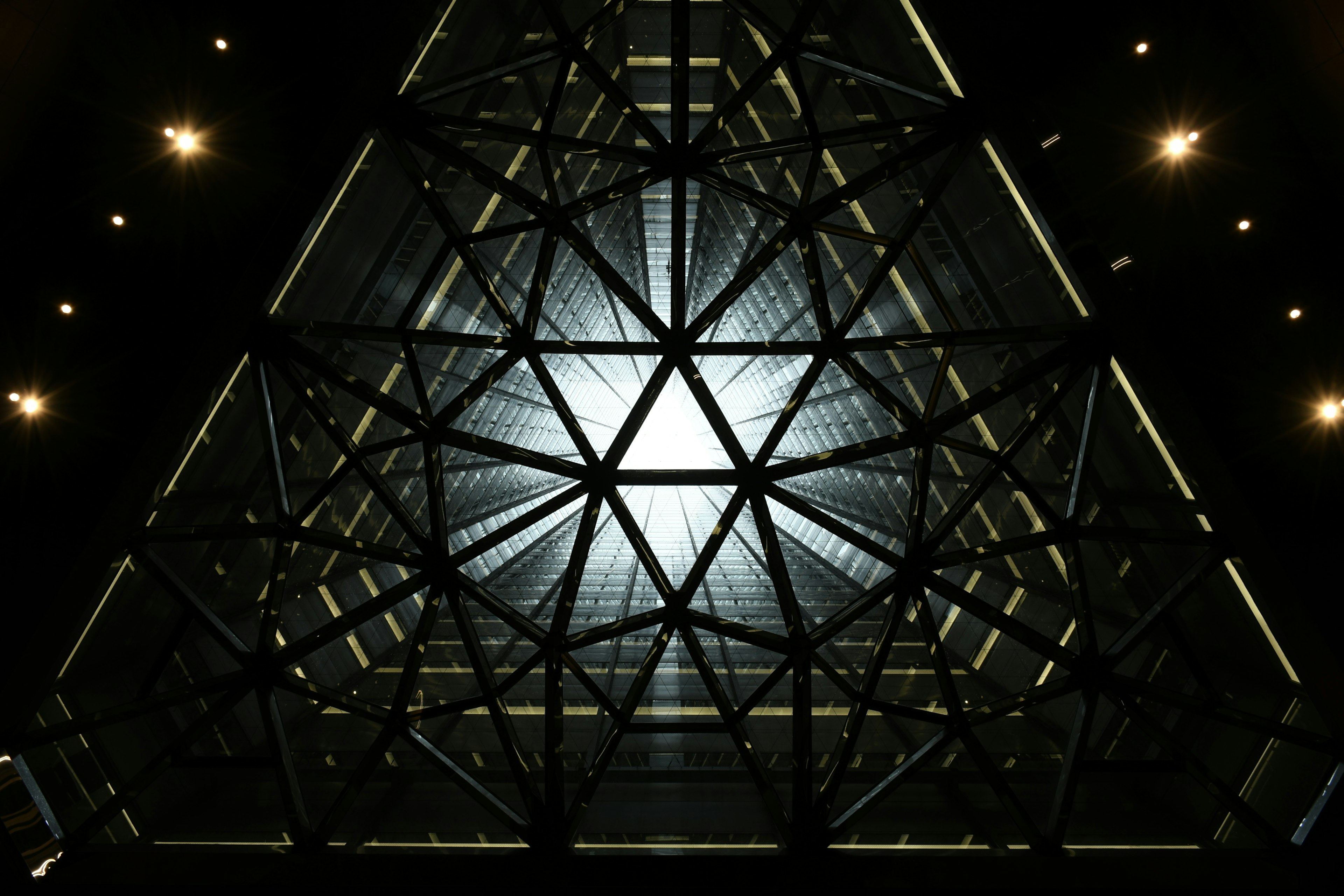 Vista interior de una estructura triangular con un fuerte contraste de luz