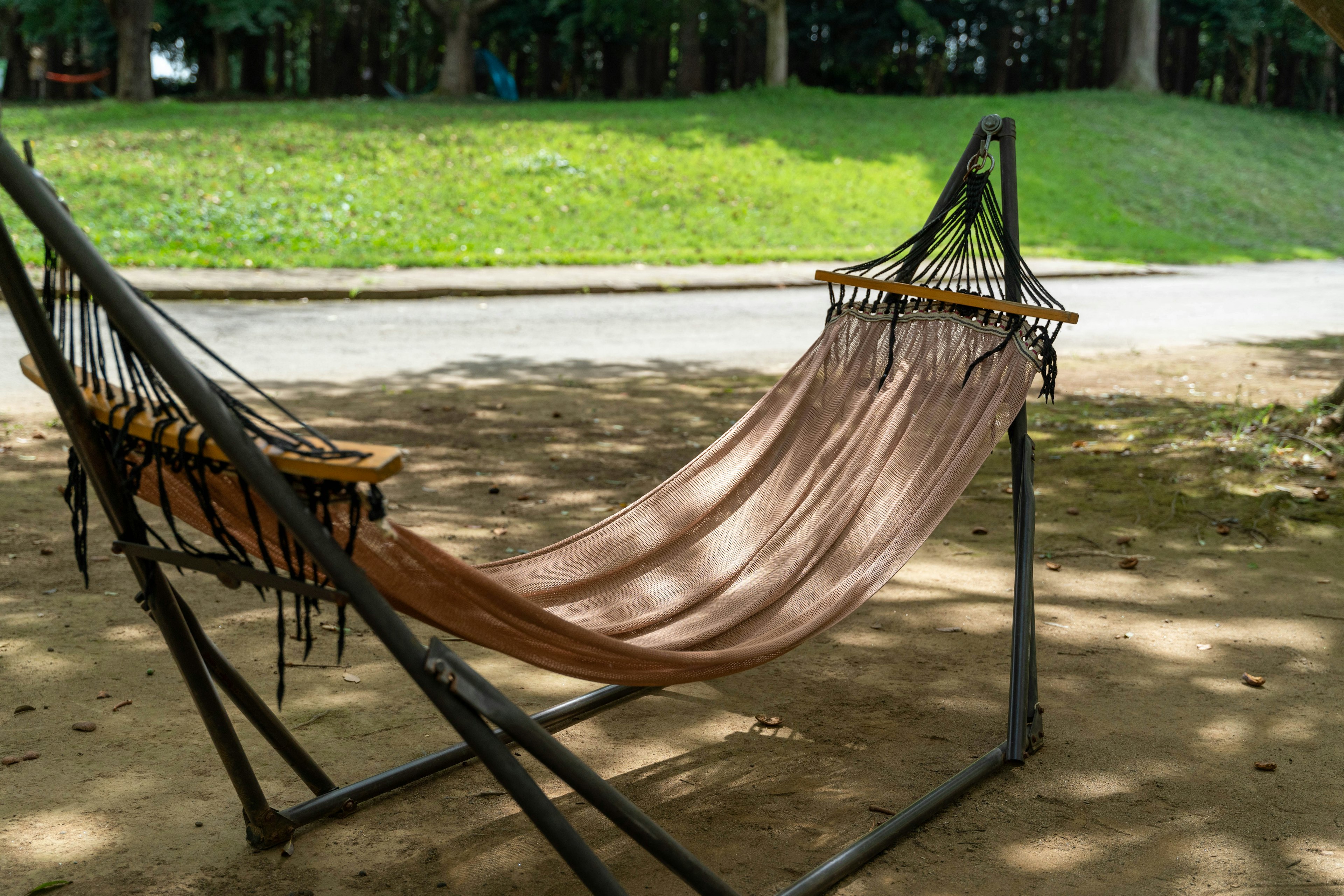 A hammock in a park shaded by trees