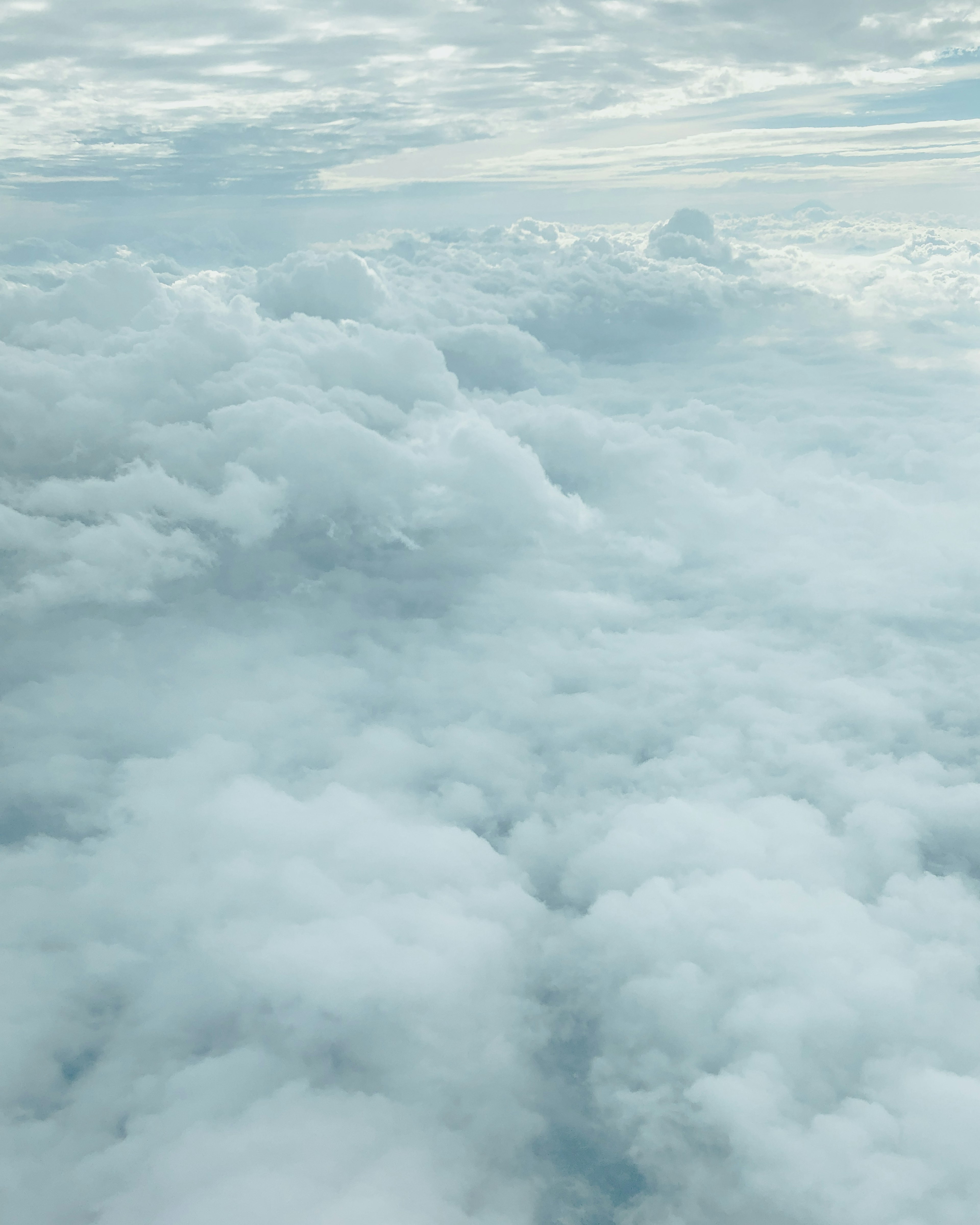 Aerial view of fluffy white clouds with a soft blue sky