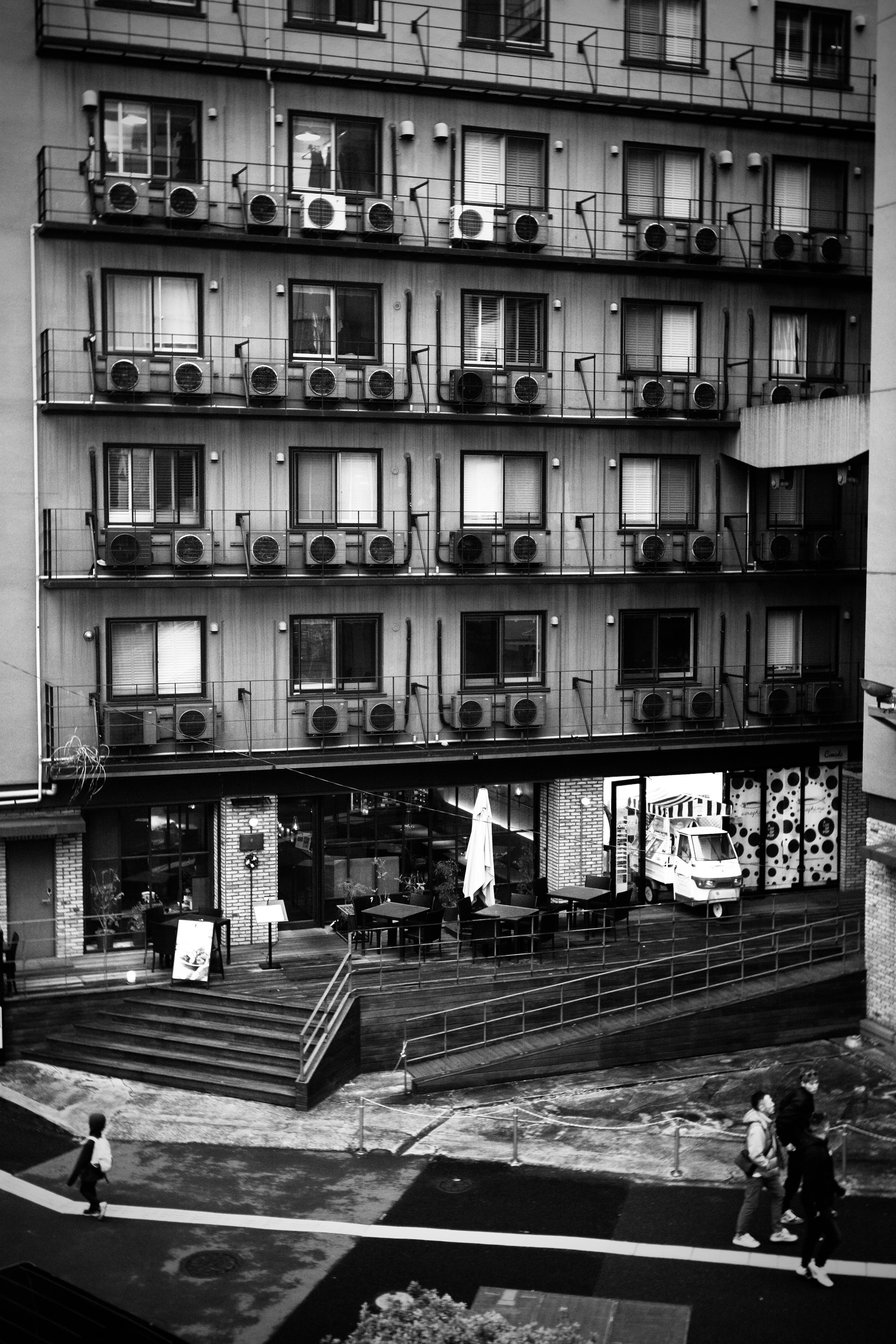 Edificio residenziale in bianco e nero con unità di condizionamento visibili