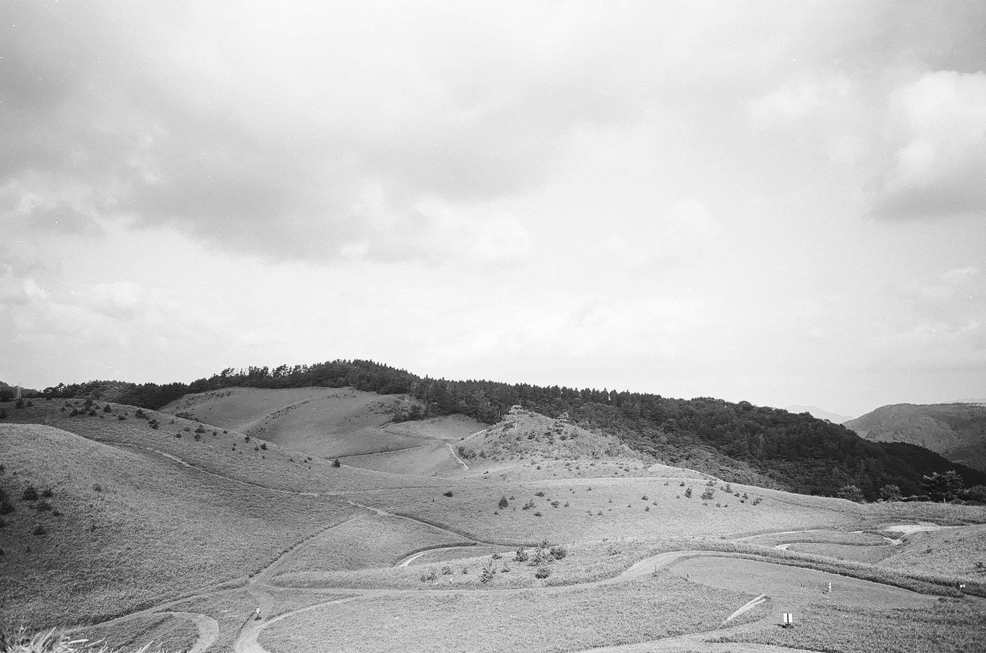 Foto di paesaggio in bianco e nero con colline ondulate e nuvole