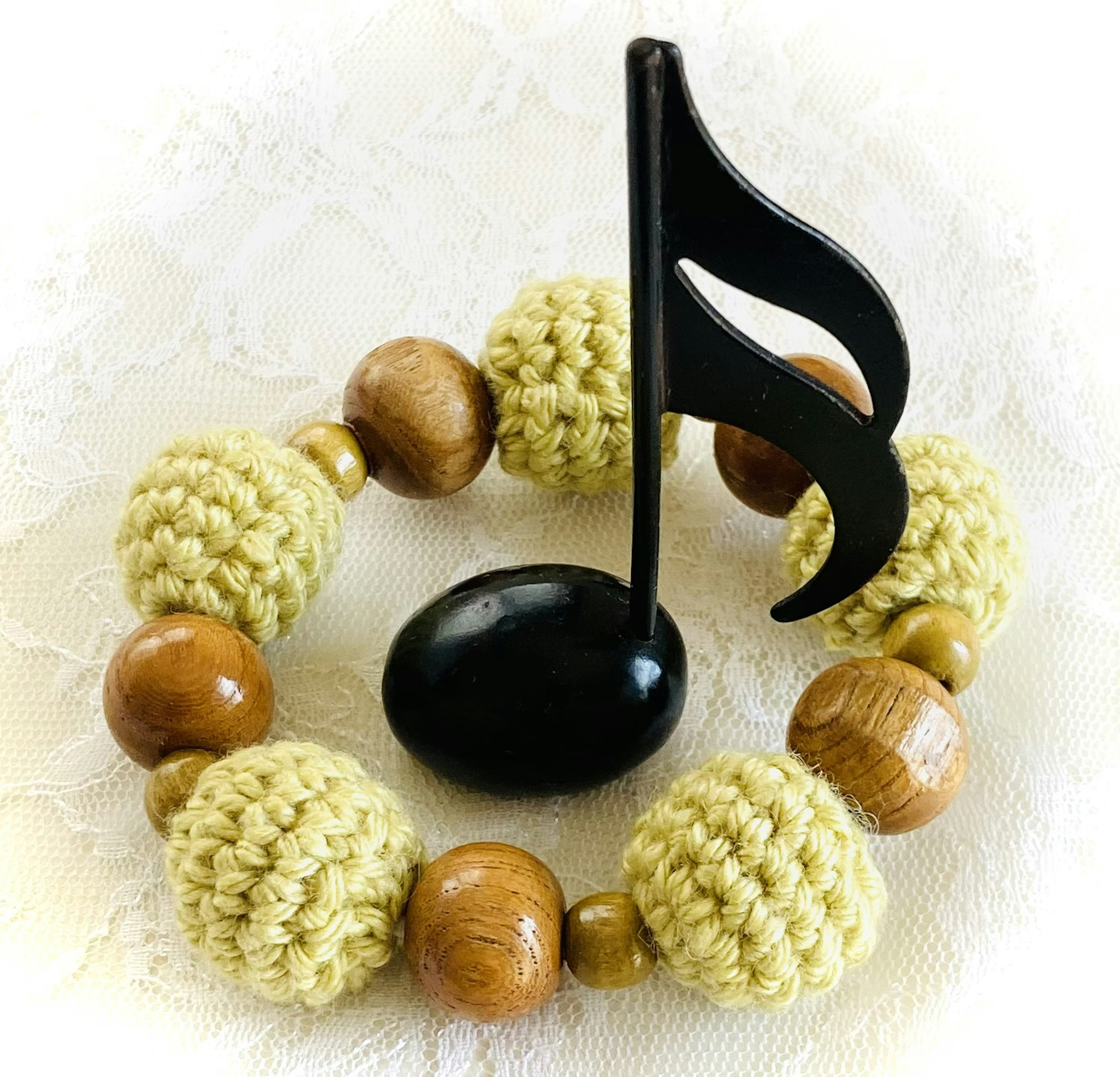 Handcrafted bracelet featuring a black musical note motif and wooden beads