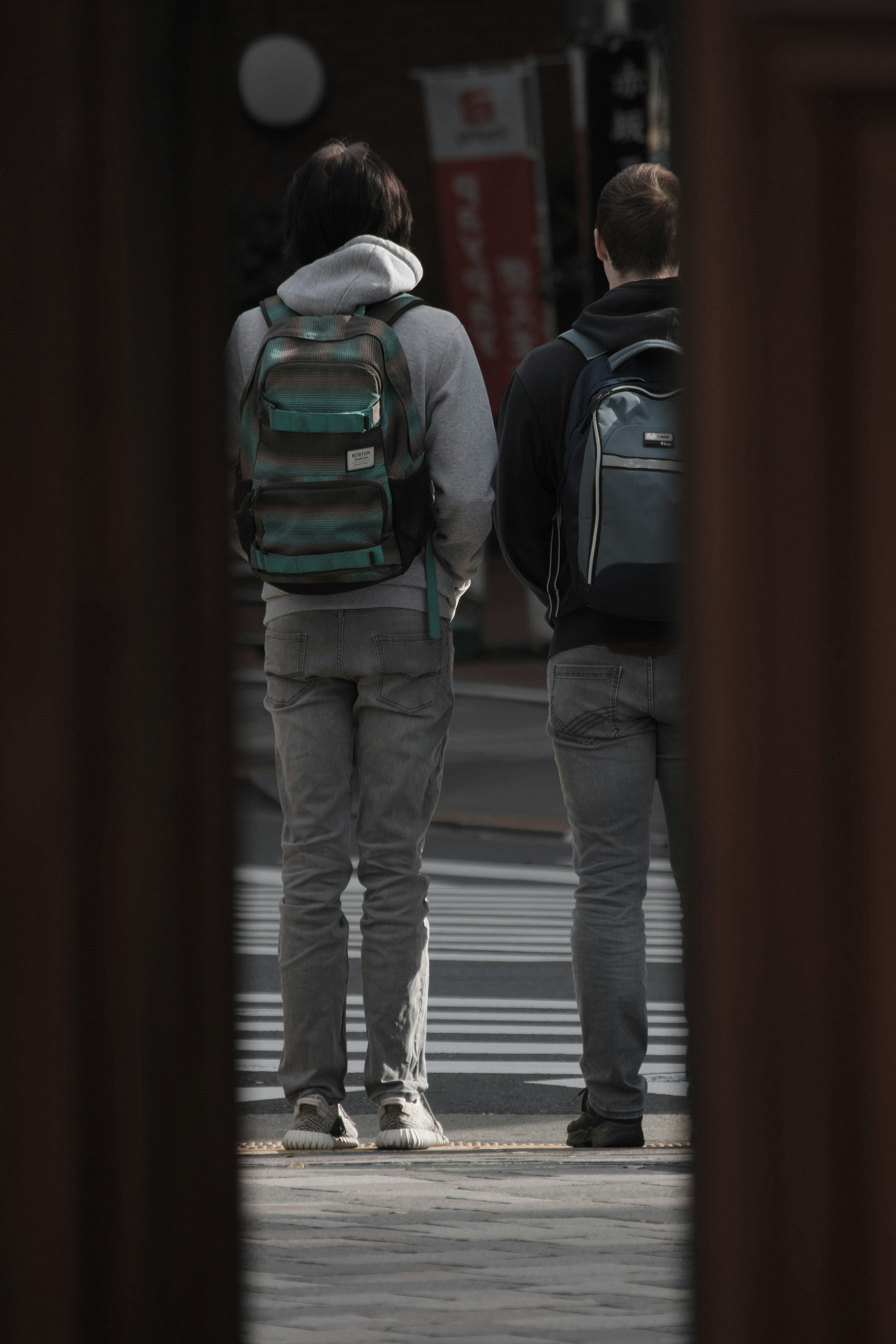 Deux hommes debout avec des sacs à dos vus de derrière