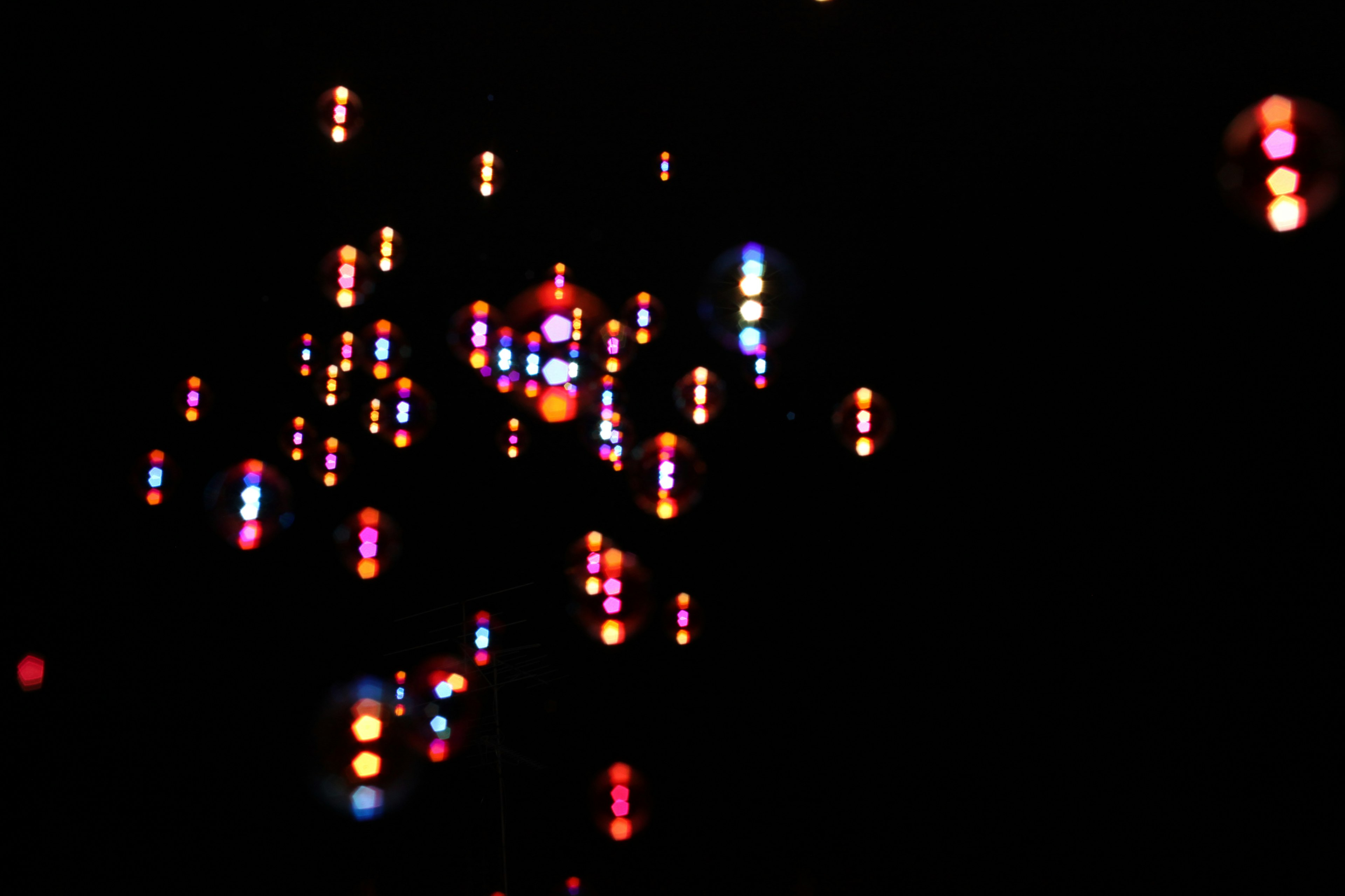 Image with colorful light dots scattered against a dark background