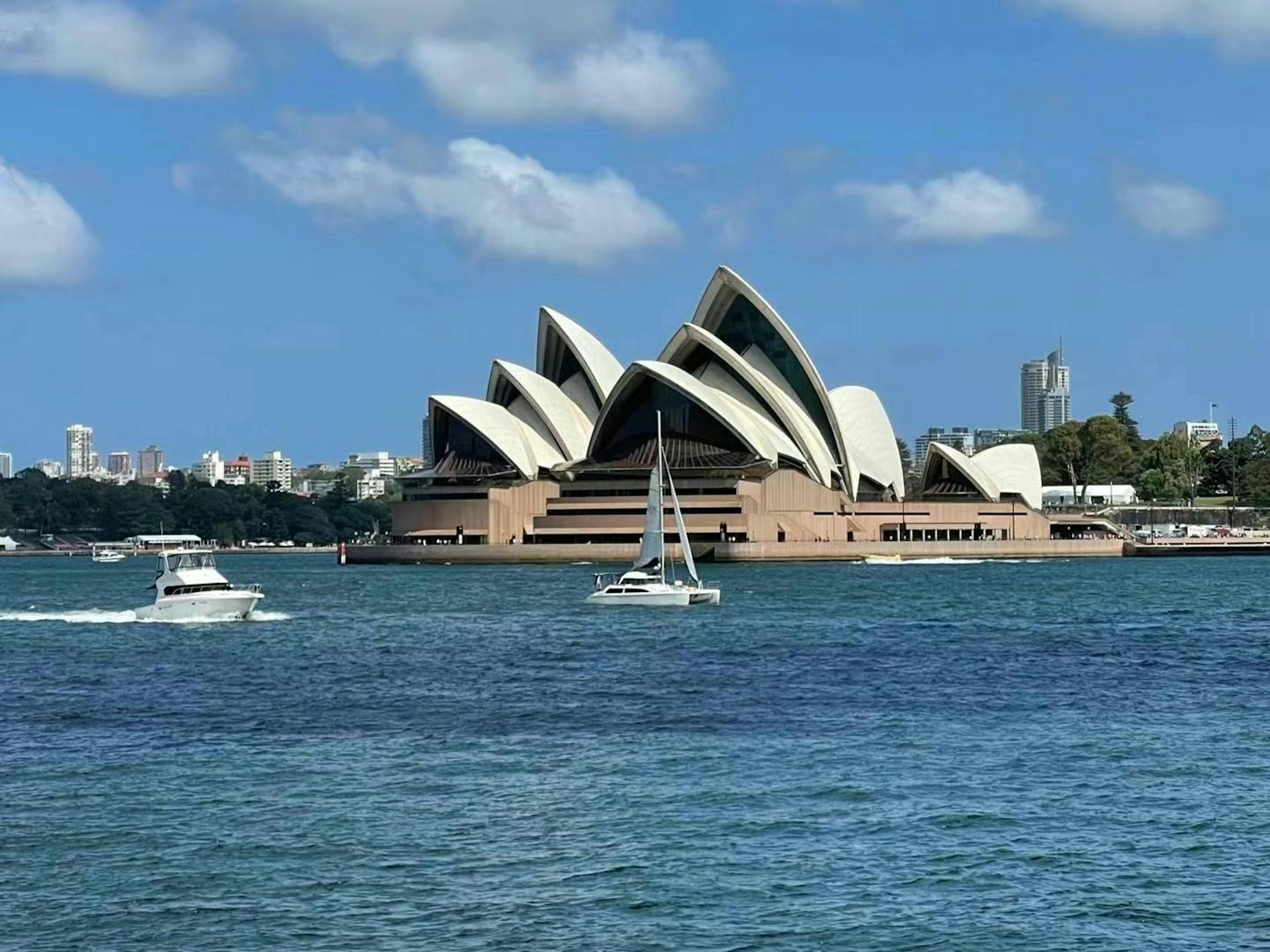 Vista de la Ópera de Sídney con barcos en el agua