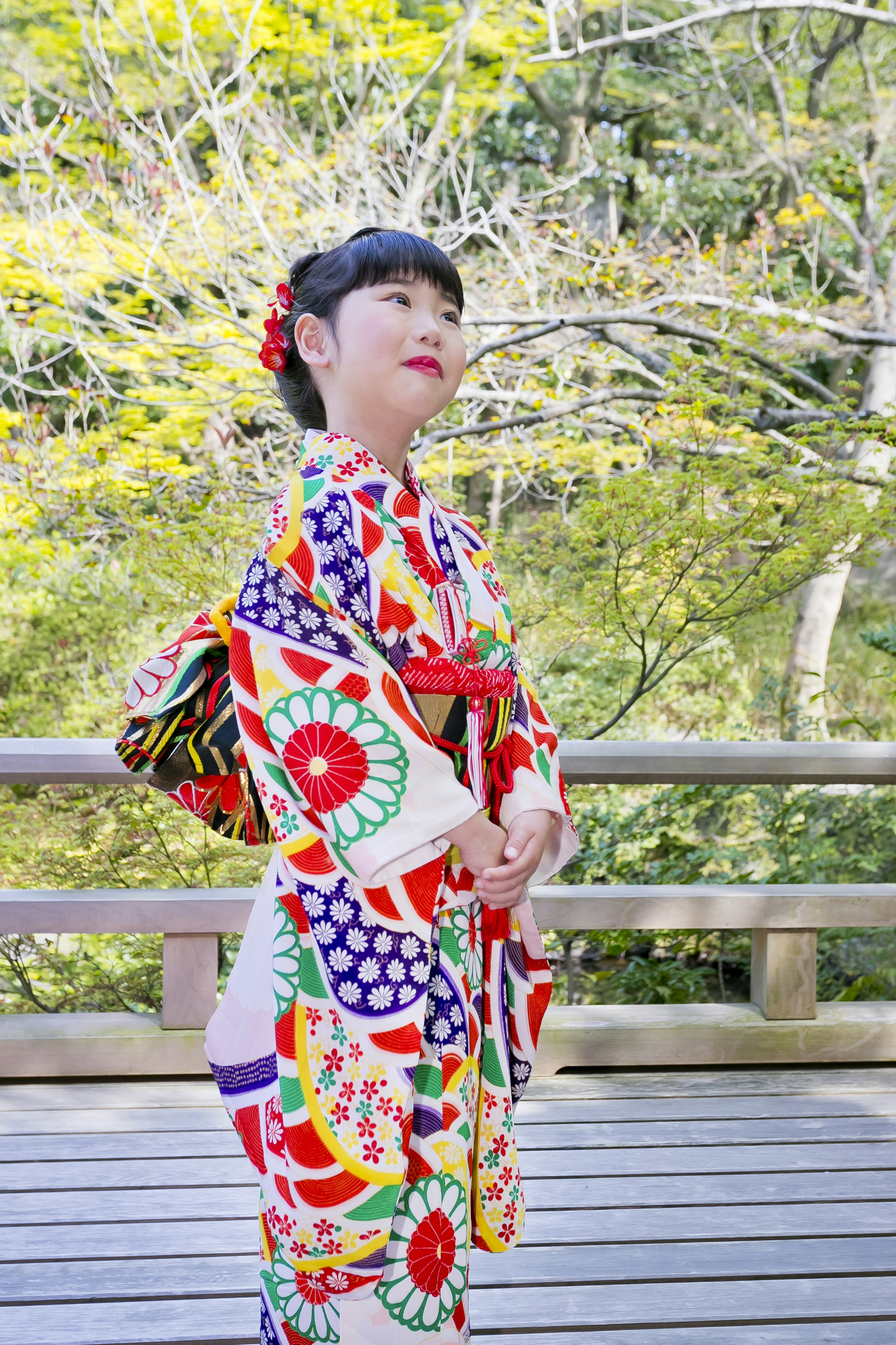 Eine Frau in einem lebhaften Kimono, die in einer natürlichen Umgebung posiert