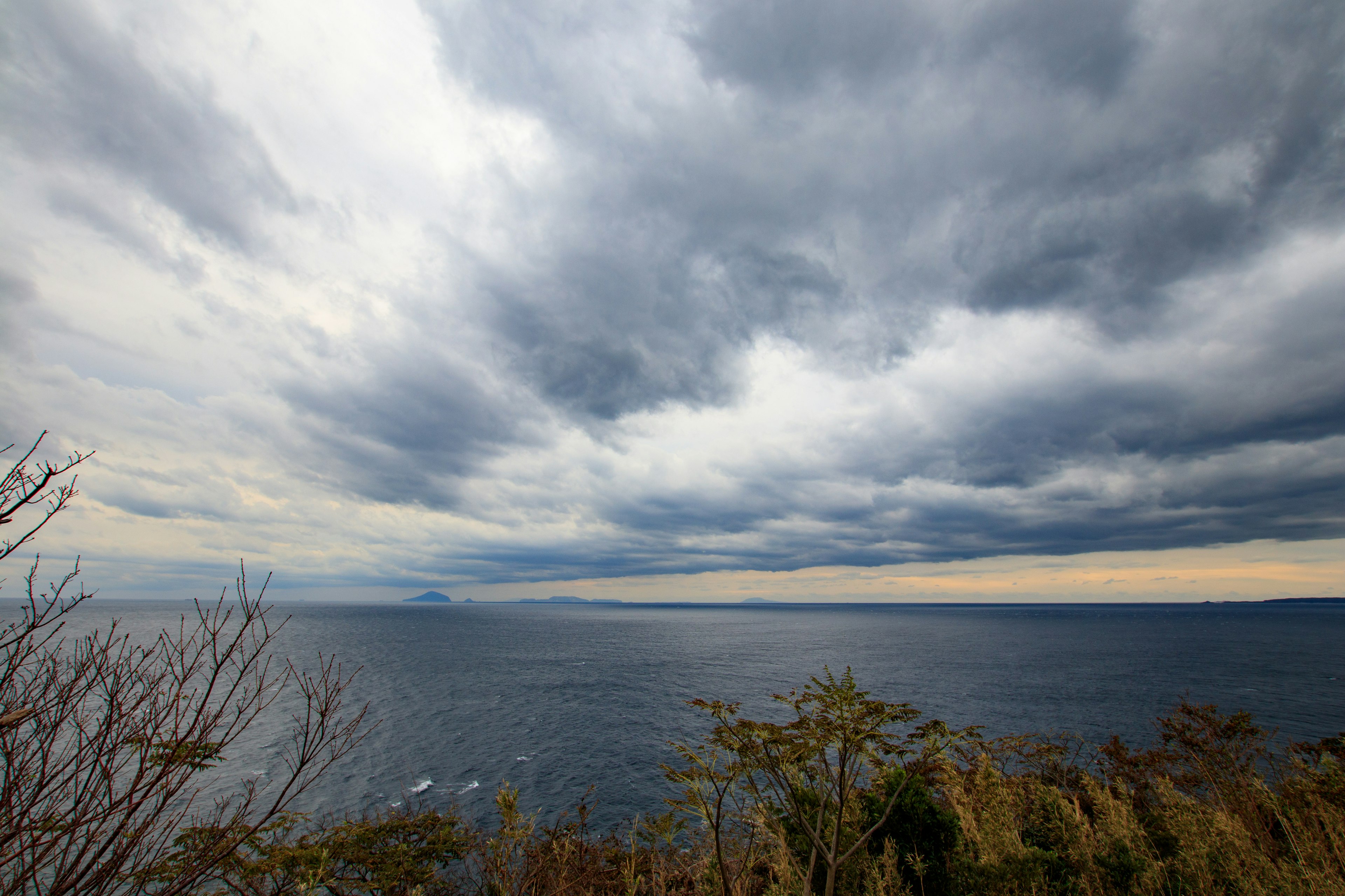 Paesaggio marino con cielo nuvoloso e montagne lontane