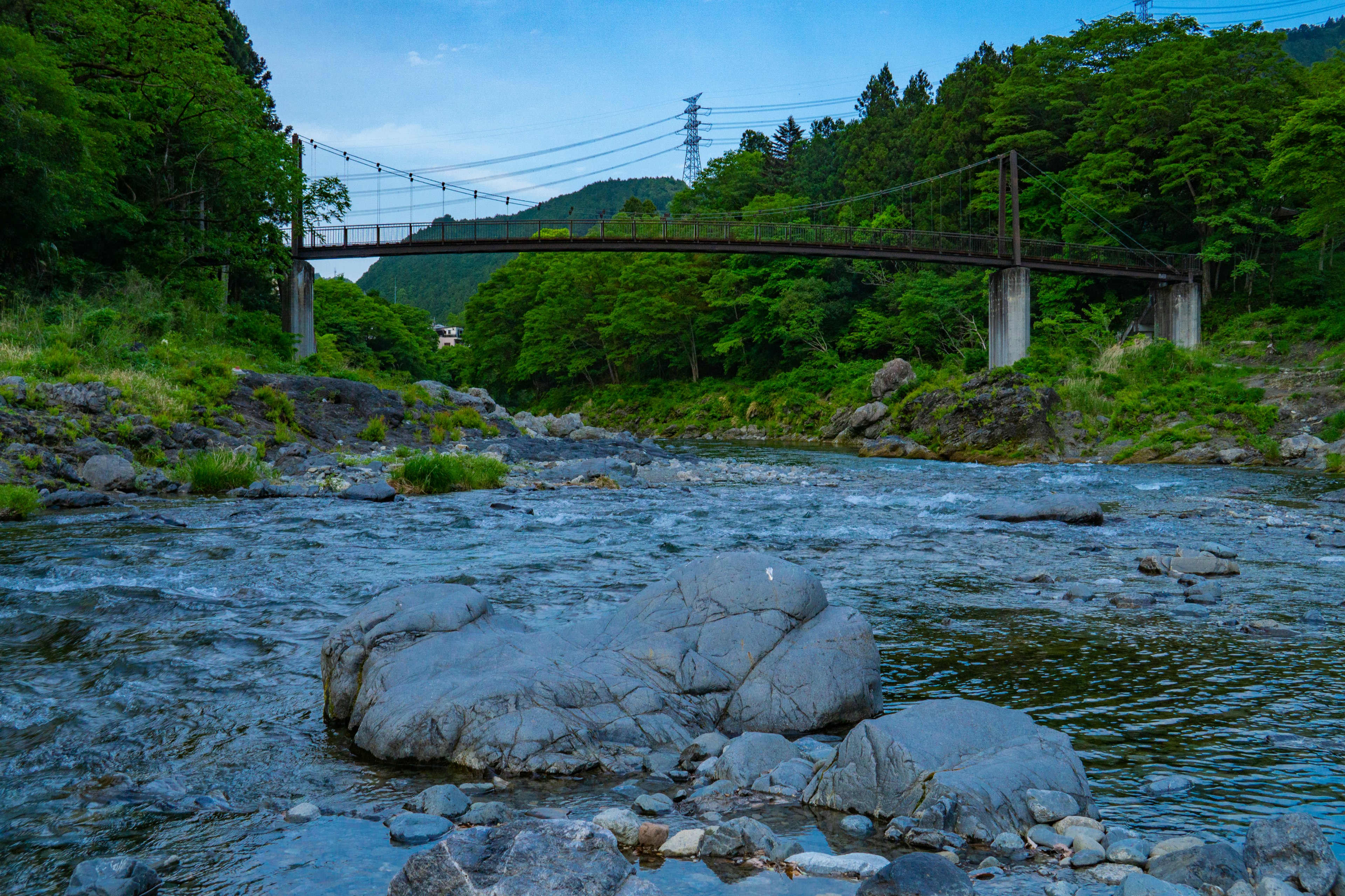 緑豊かな山々と鉄橋が見える清流の風景