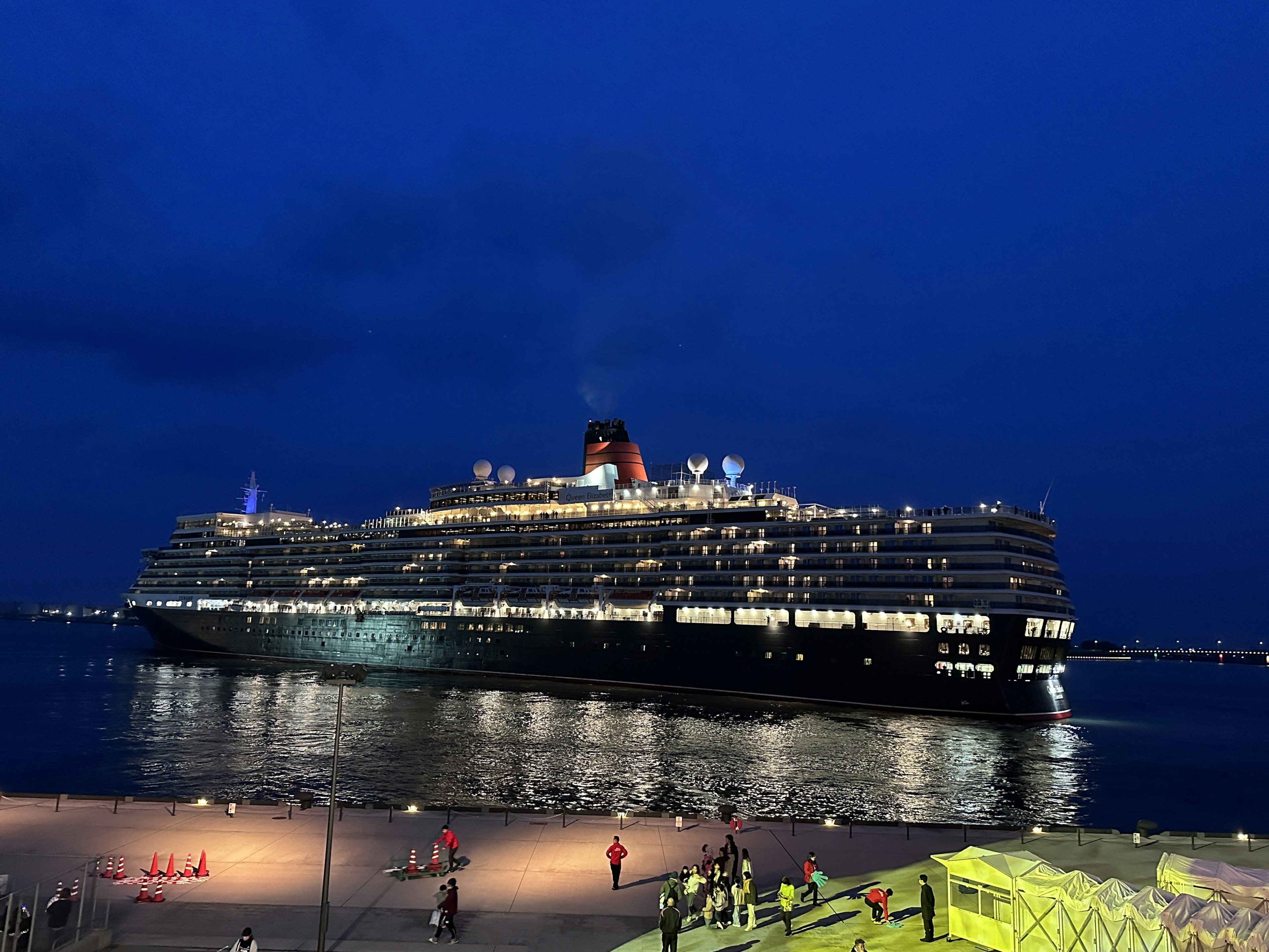 A luxurious cruise ship illuminated at night on calm waters