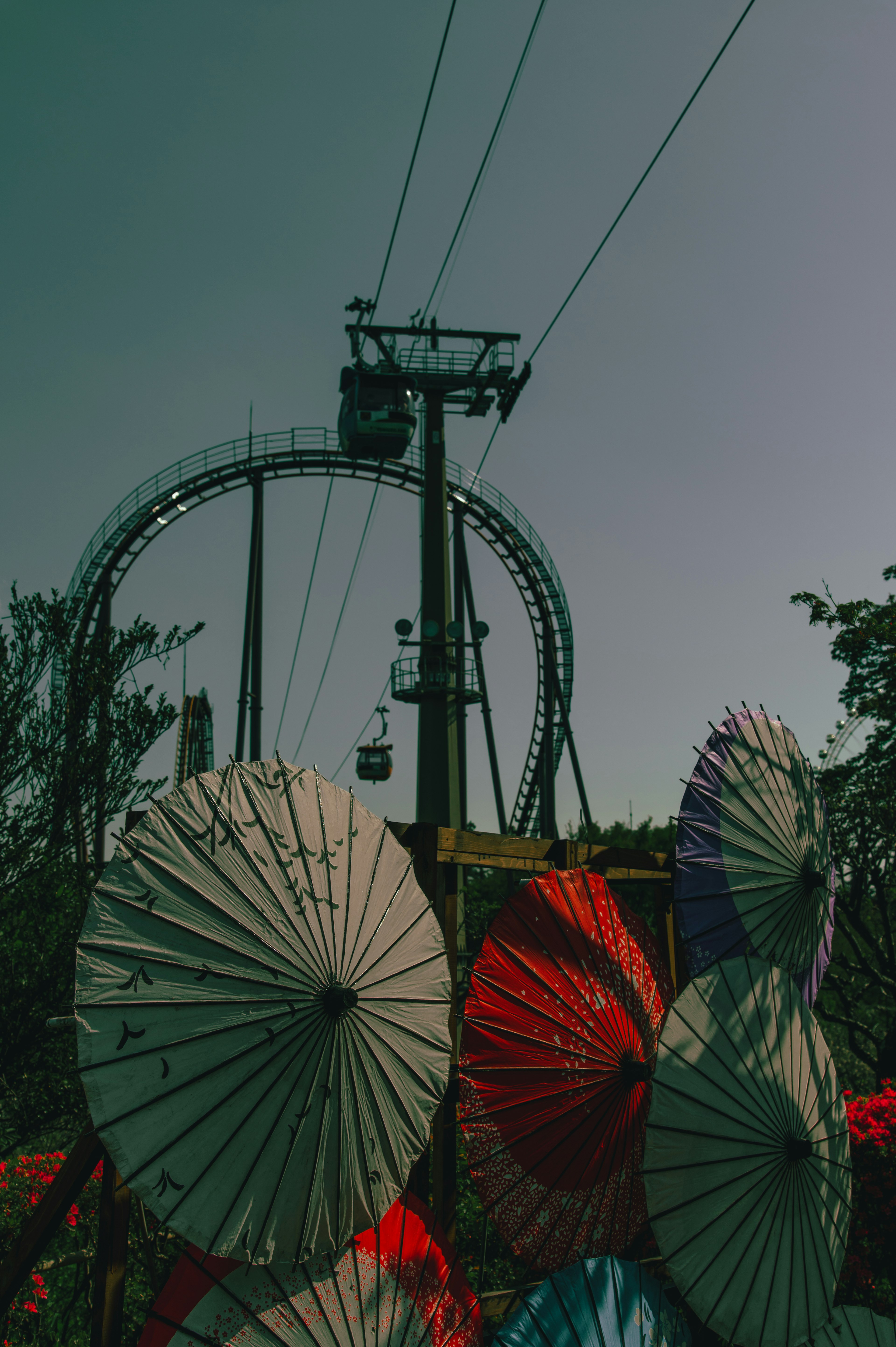 Bunte Regenschirme mit einer Seilbahn im Hintergrund