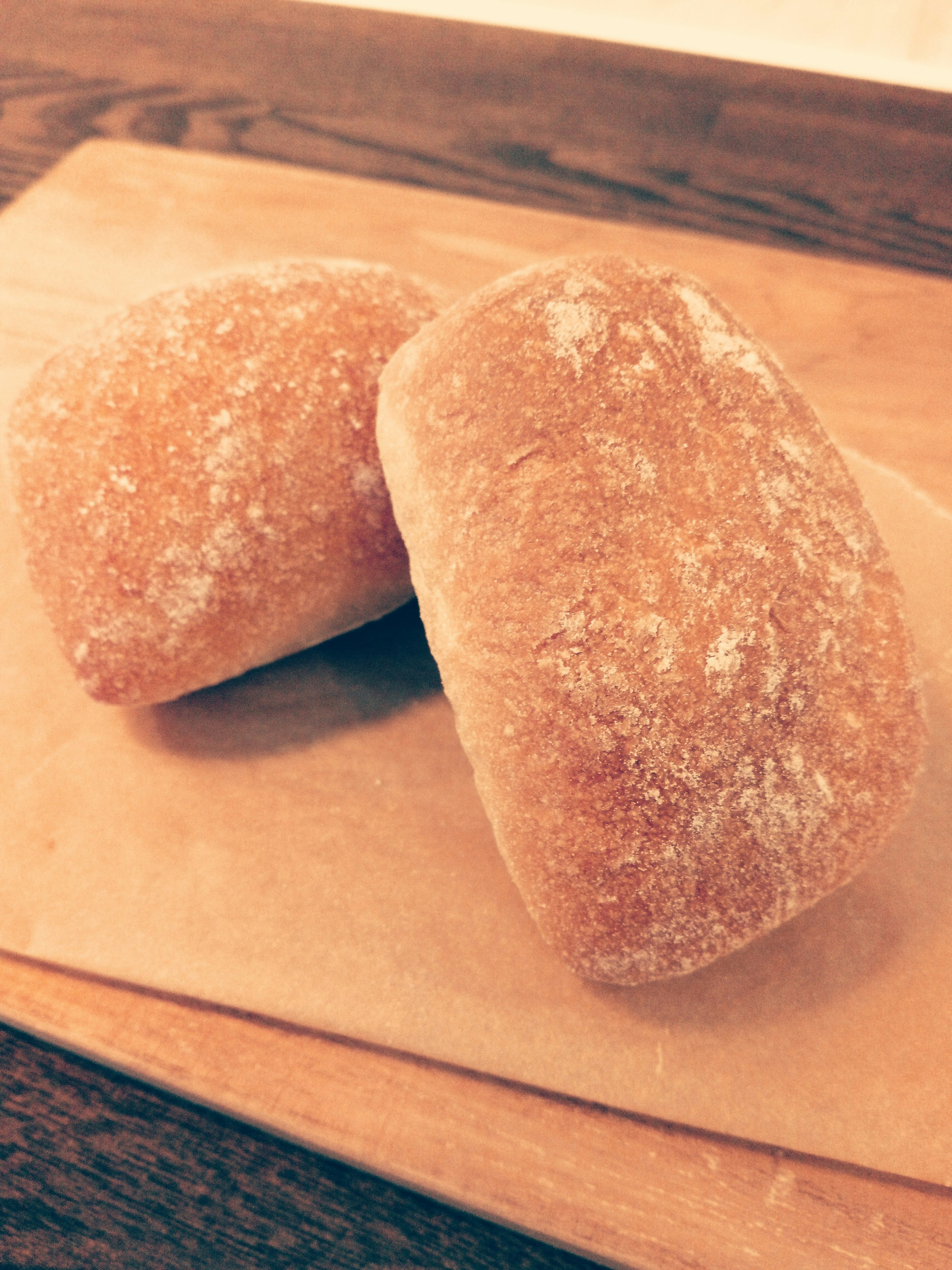 Two pieces of bread on a wooden board