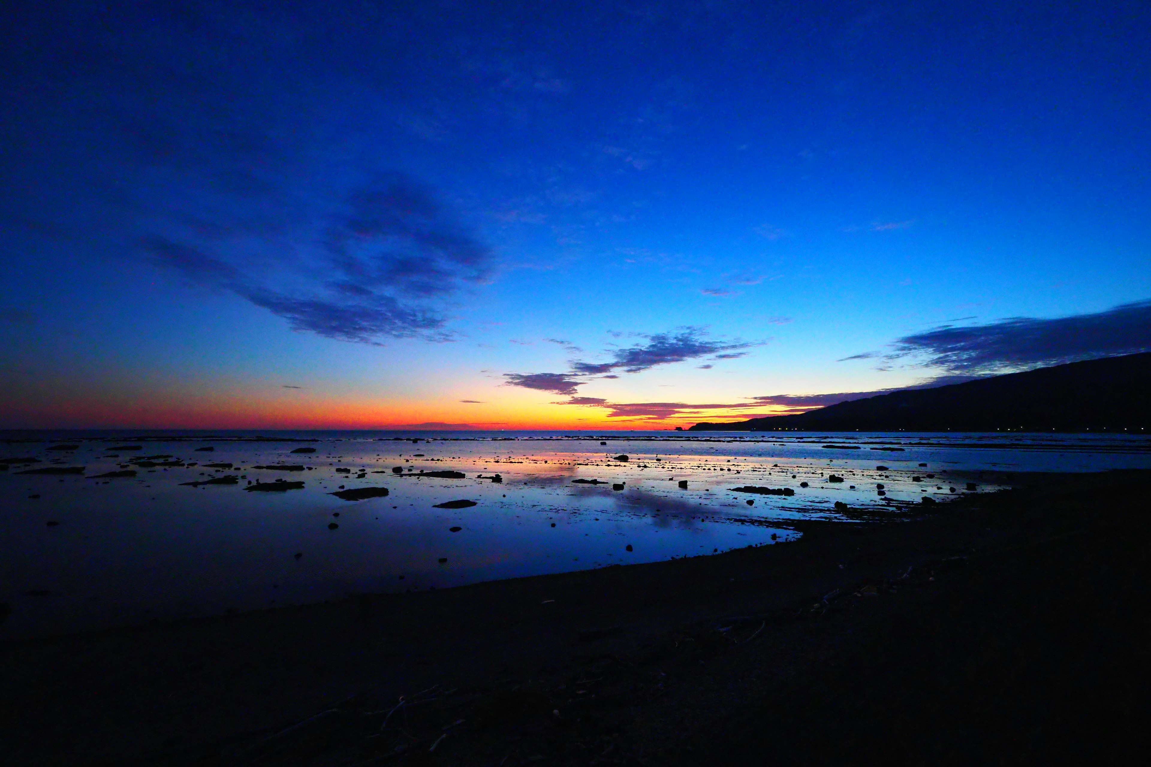 Schöner Sonnenuntergang über dem Ozean mit tiefblauem Himmel und orangefarbenem Lichtkontrast