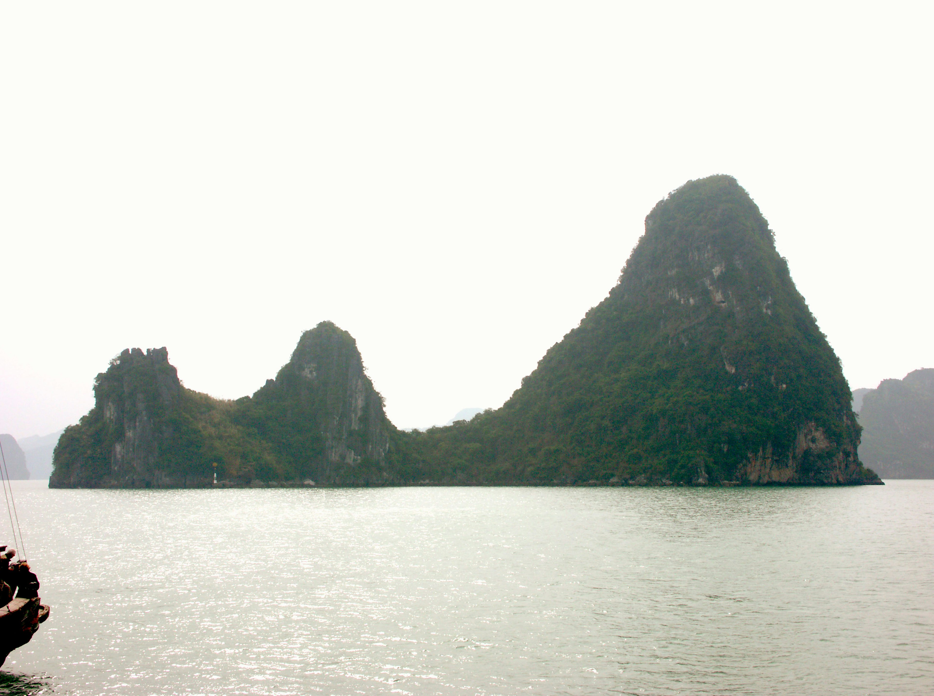 Islands resembling tall mountains shrouded in mist over the sea