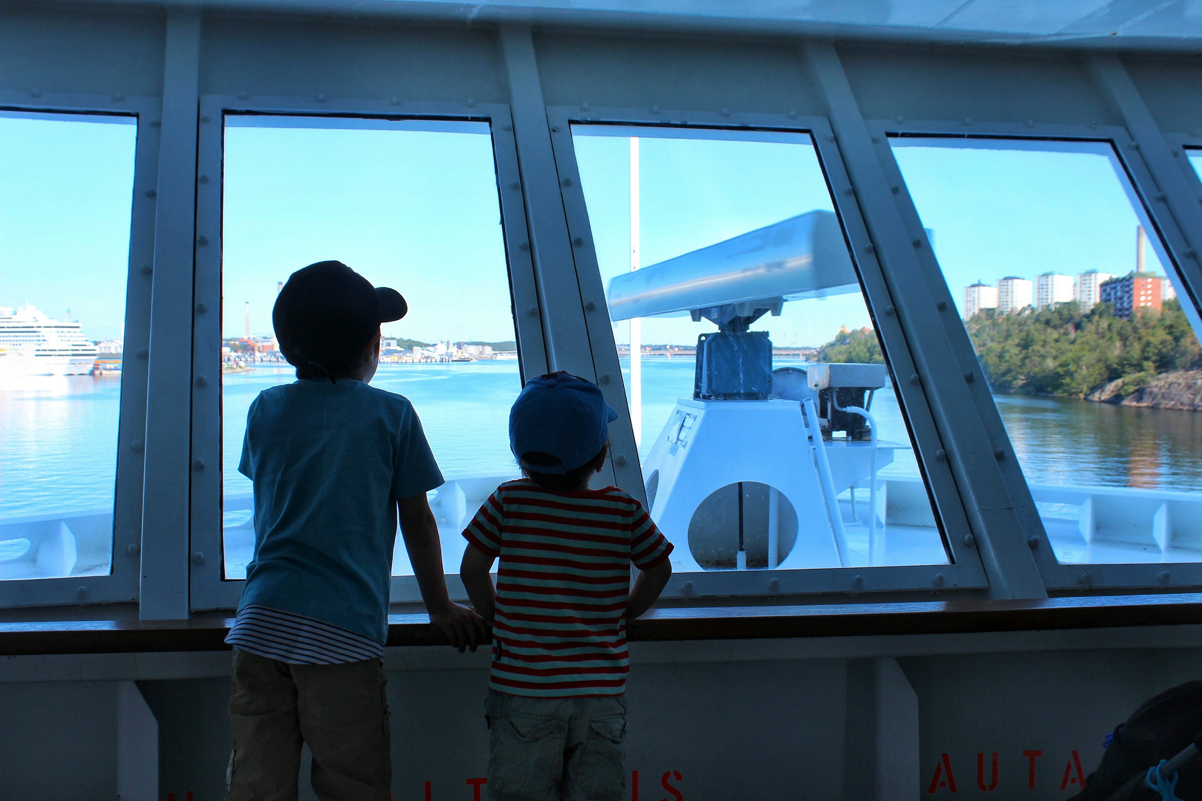 Zwei Kinder schauen aus einem Schifffenster