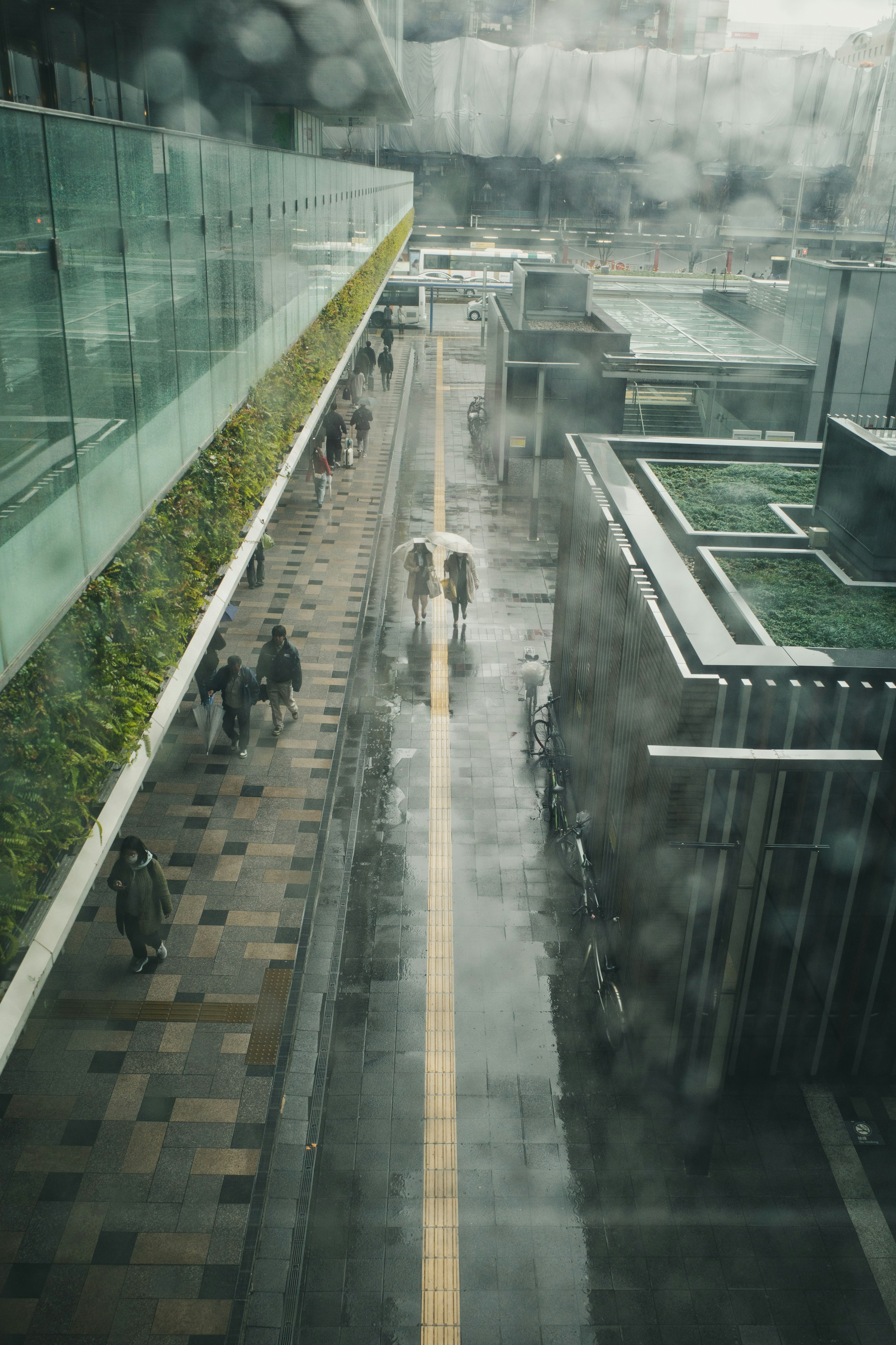 Urban street scene in the rain with silhouettes of people