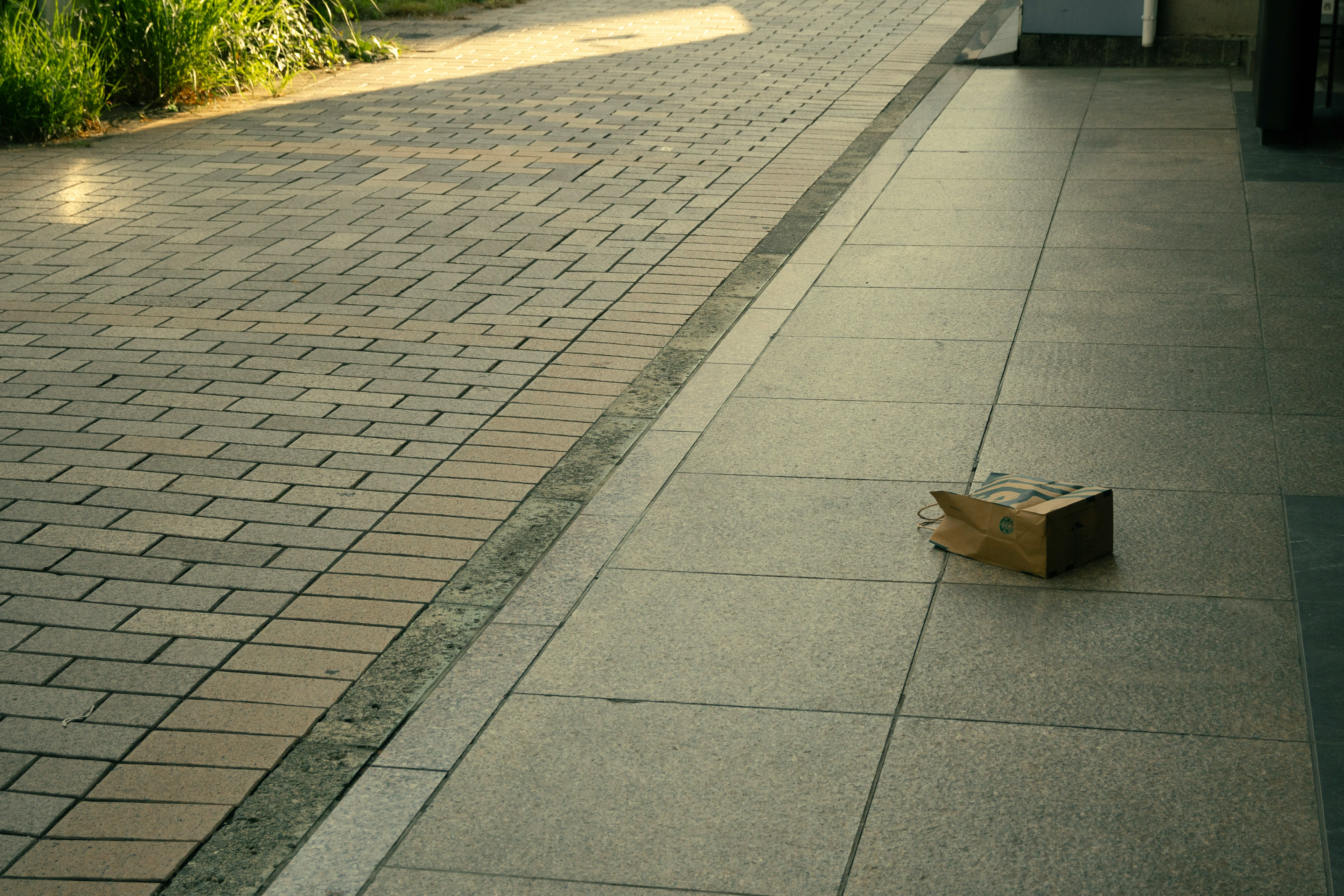 歩道に置かれた段ボール箱と石畳の風景