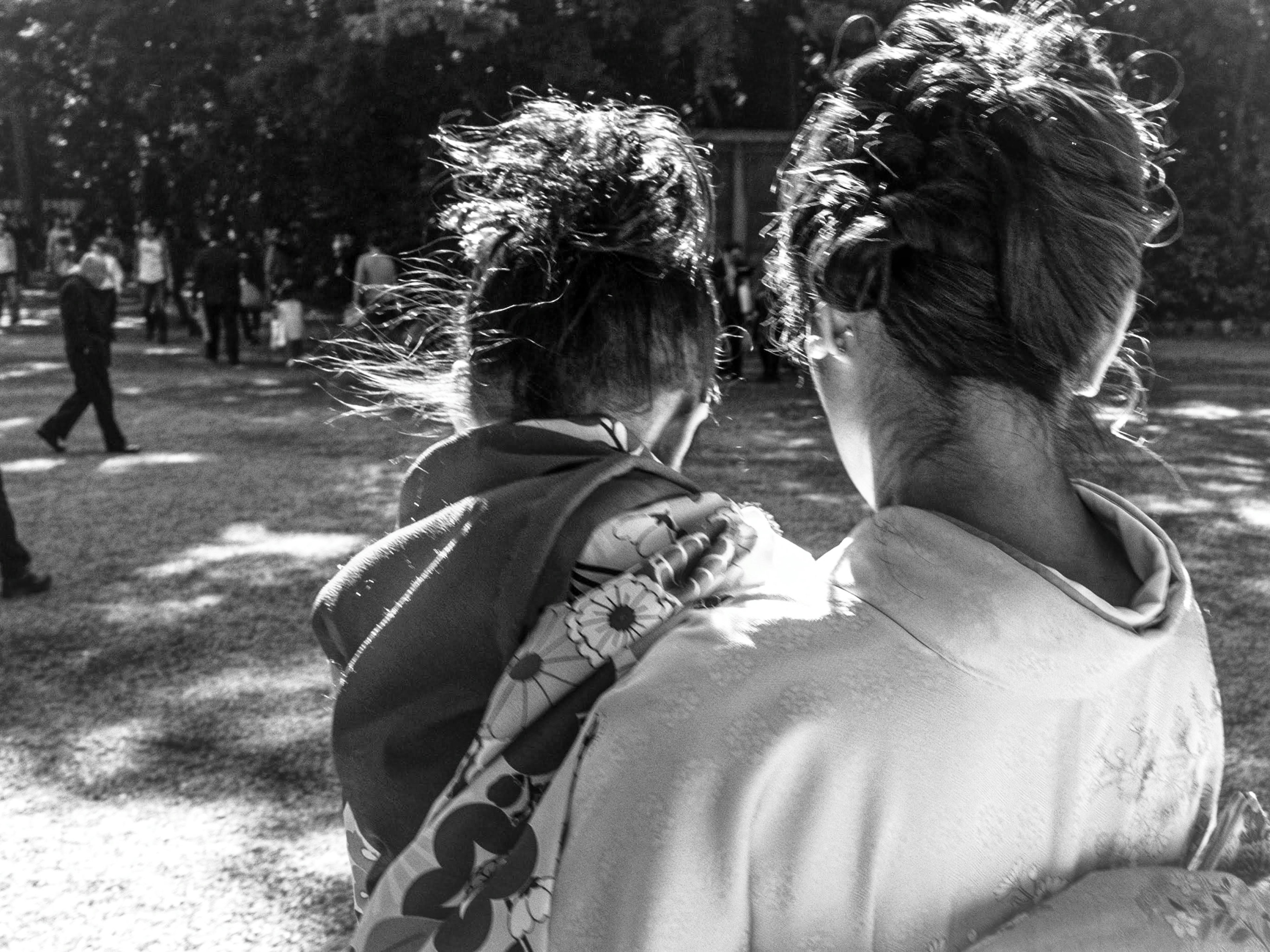 Una mujer sosteniendo a un niño vista desde atrás en un parque