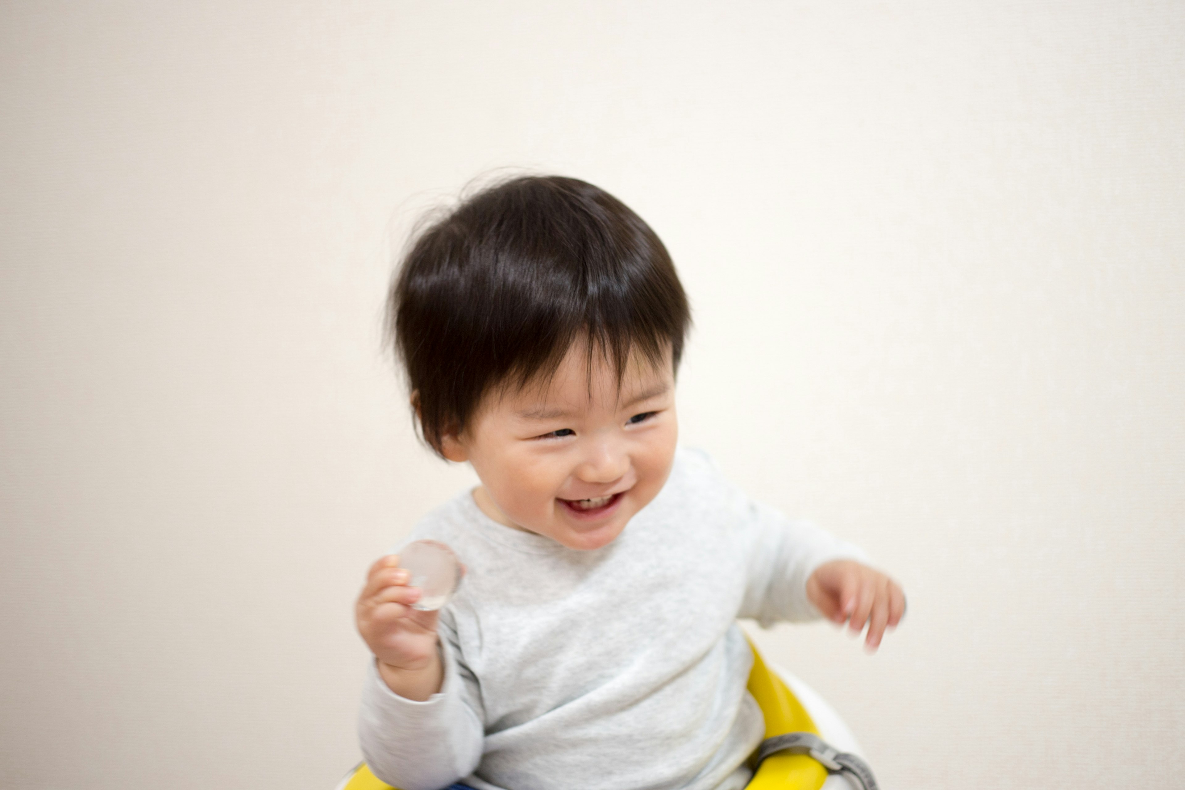 Bambino sorridente seduto su una sedia gialla