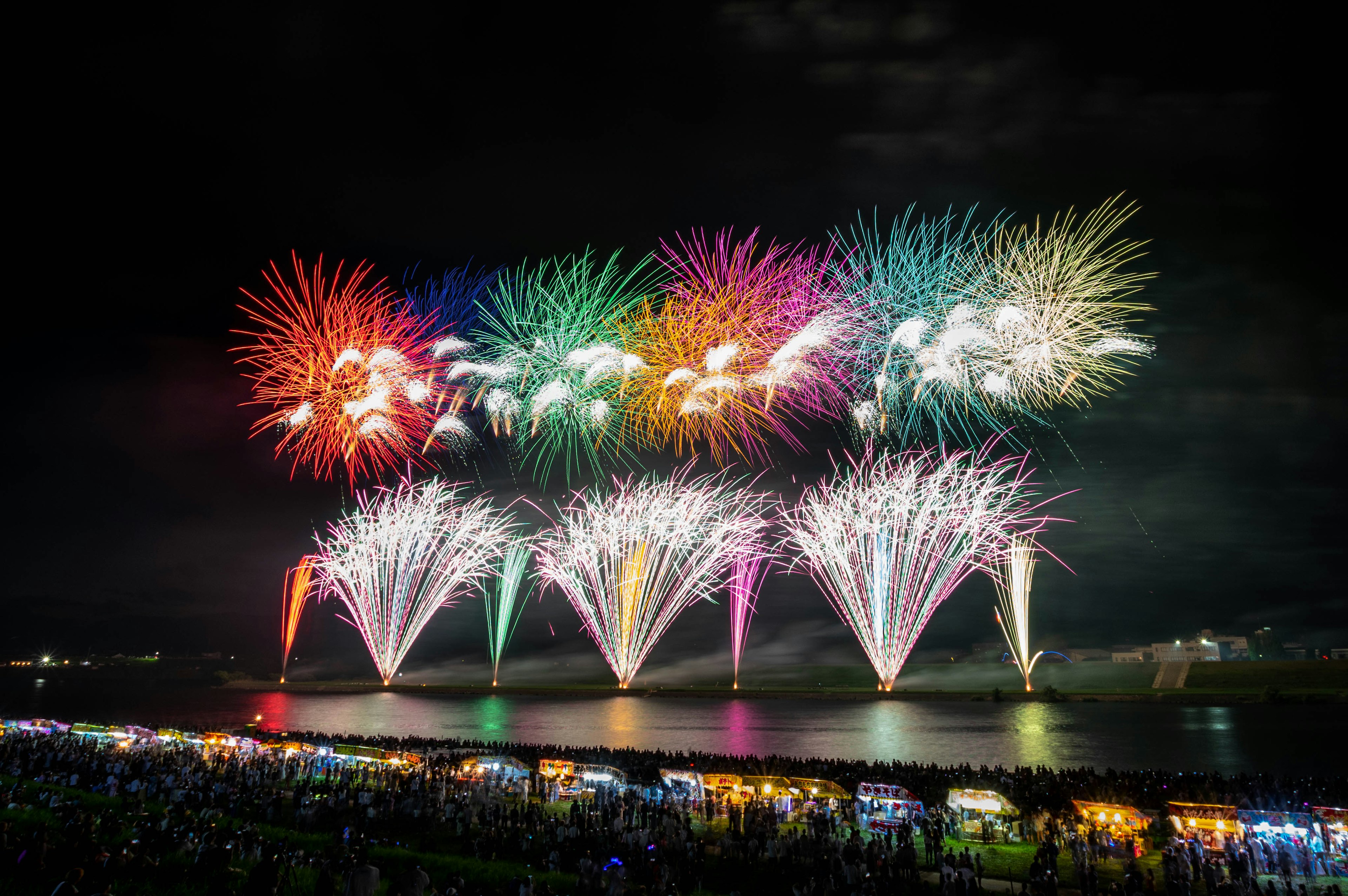 Colorful fireworks display lighting up the night sky over a crowd