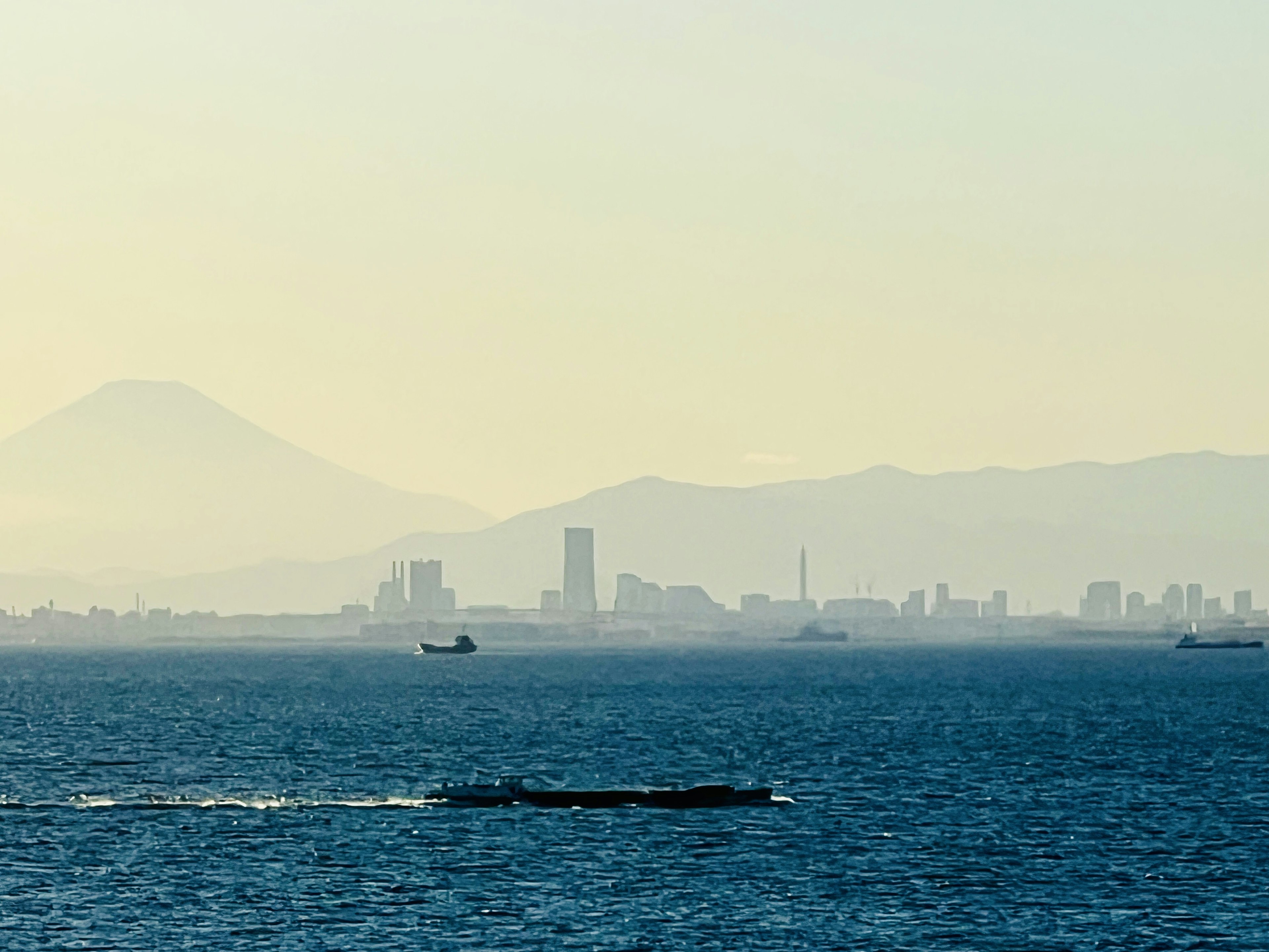 海と遠くの山々が見える風景にボートが浮かんでいる