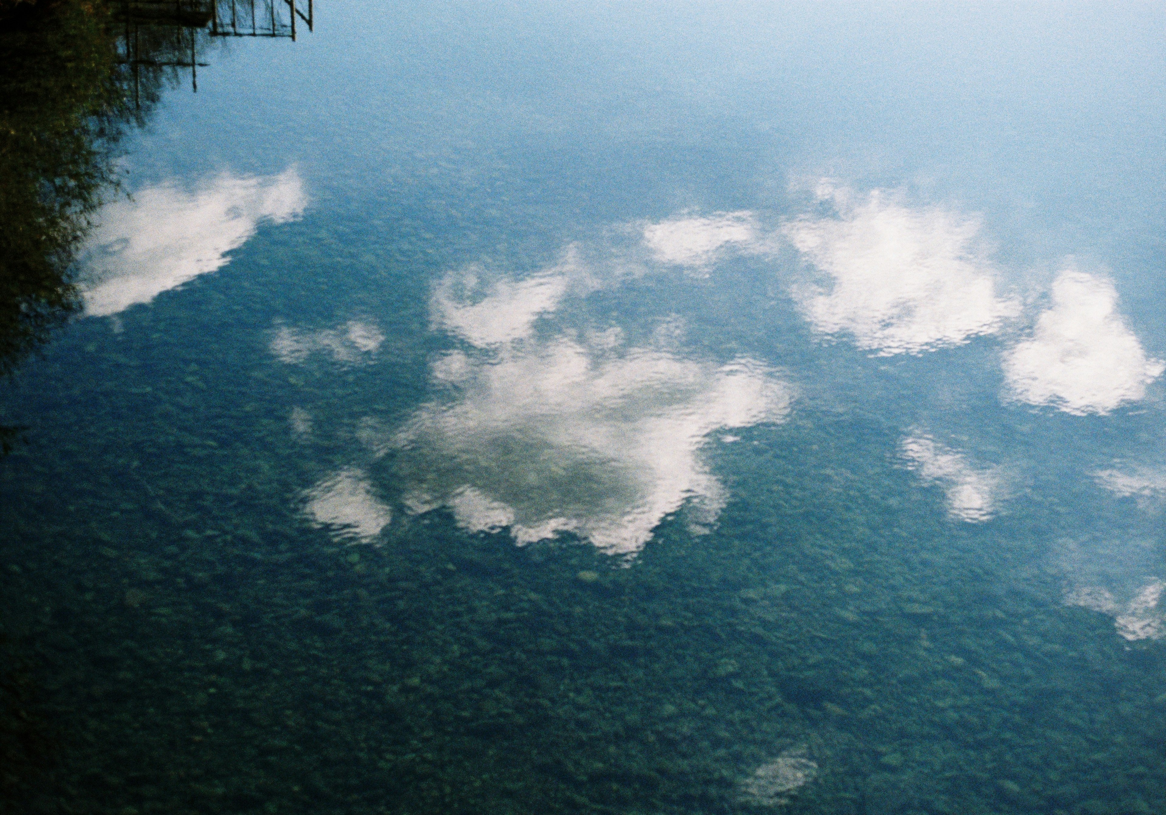 Reflexion von Wolken auf der ruhigen Wasseroberfläche