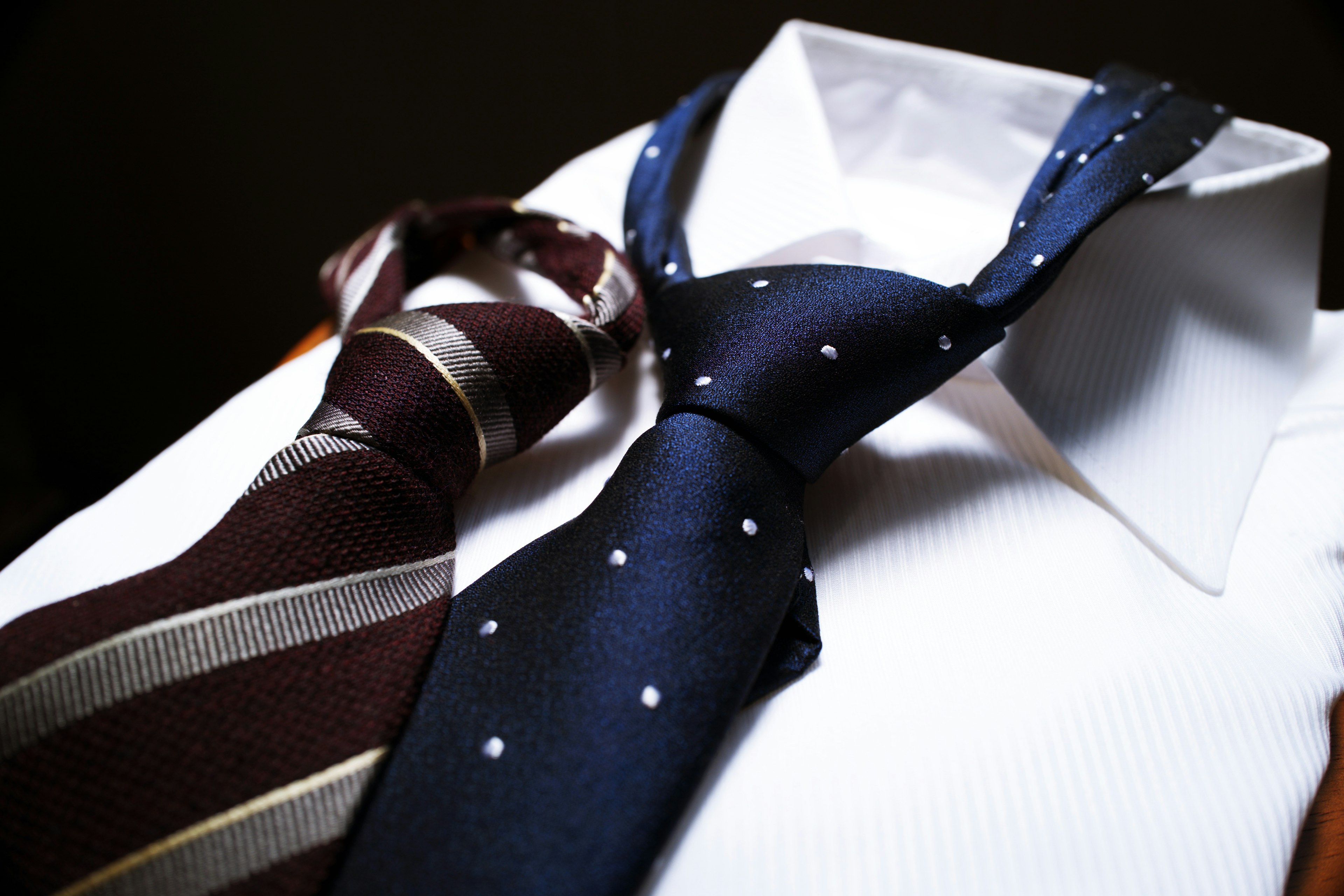 Blue polka dot tie and brown striped tie on a white shirt