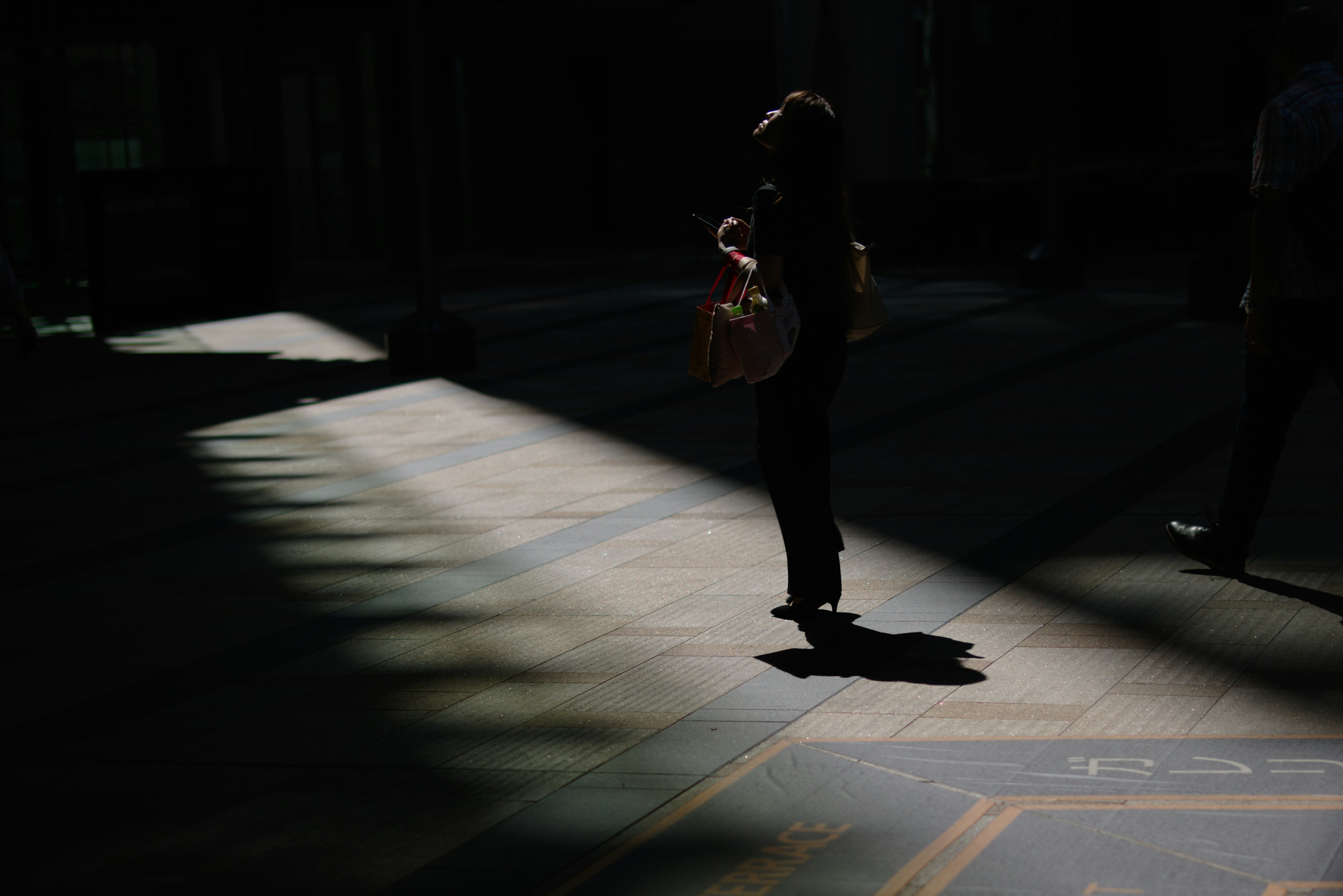 Silhouette seseorang berdiri di ruang gelap dengan cahaya di lantai